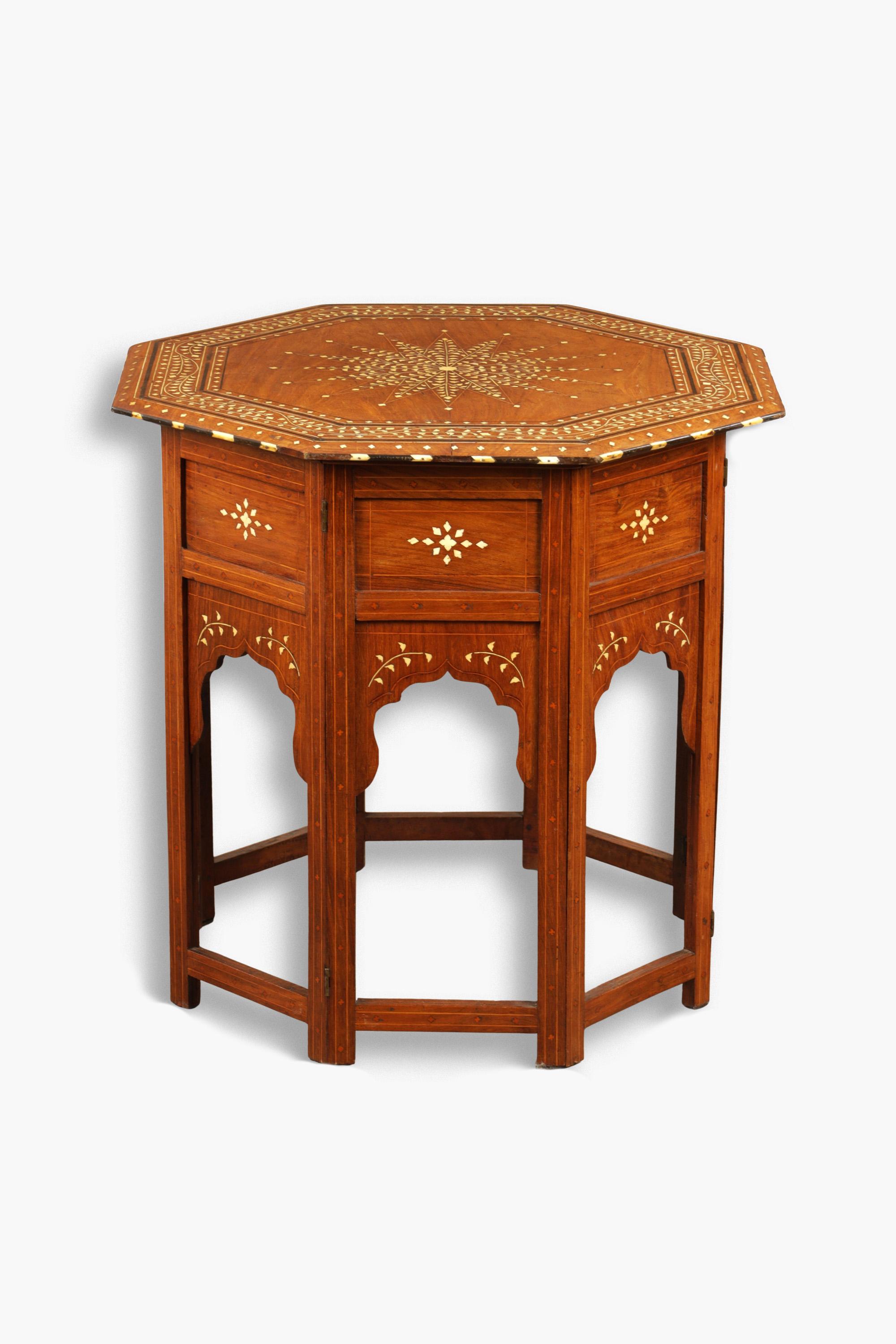 19th Century bone inlaid sandalwood centre table. The octagonal top with scrolling foliate border and star motif centre raised on a folding panelled base.

Good original condition. Minor losses to inlay commensurate age.