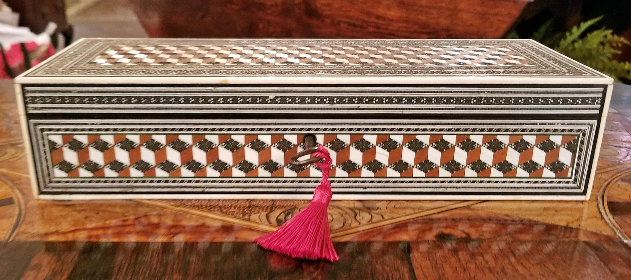 Very nice 19th century Anglo-Indian glove box from circa 1870.
Made from sandalwood but heavily inlaid with Bombay Sadeli mosaic and tumbleblock geometric patterns all over.

Under the lid there is a sadeli mosaic medallion.

The box is edged