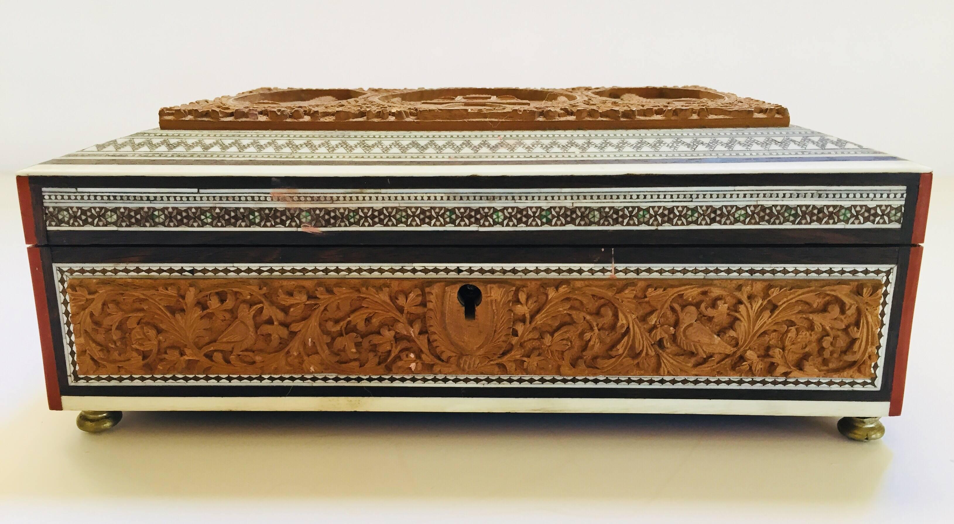 19th century Anglo-Indian sandal wood box, Sadeli mosaic box fitted with various compartments finely hand-carved with the Taj Mahal.
Of sarcophagus form with carved and inlaid decoration, the interior with a compartmentalized and lidded tray.
The