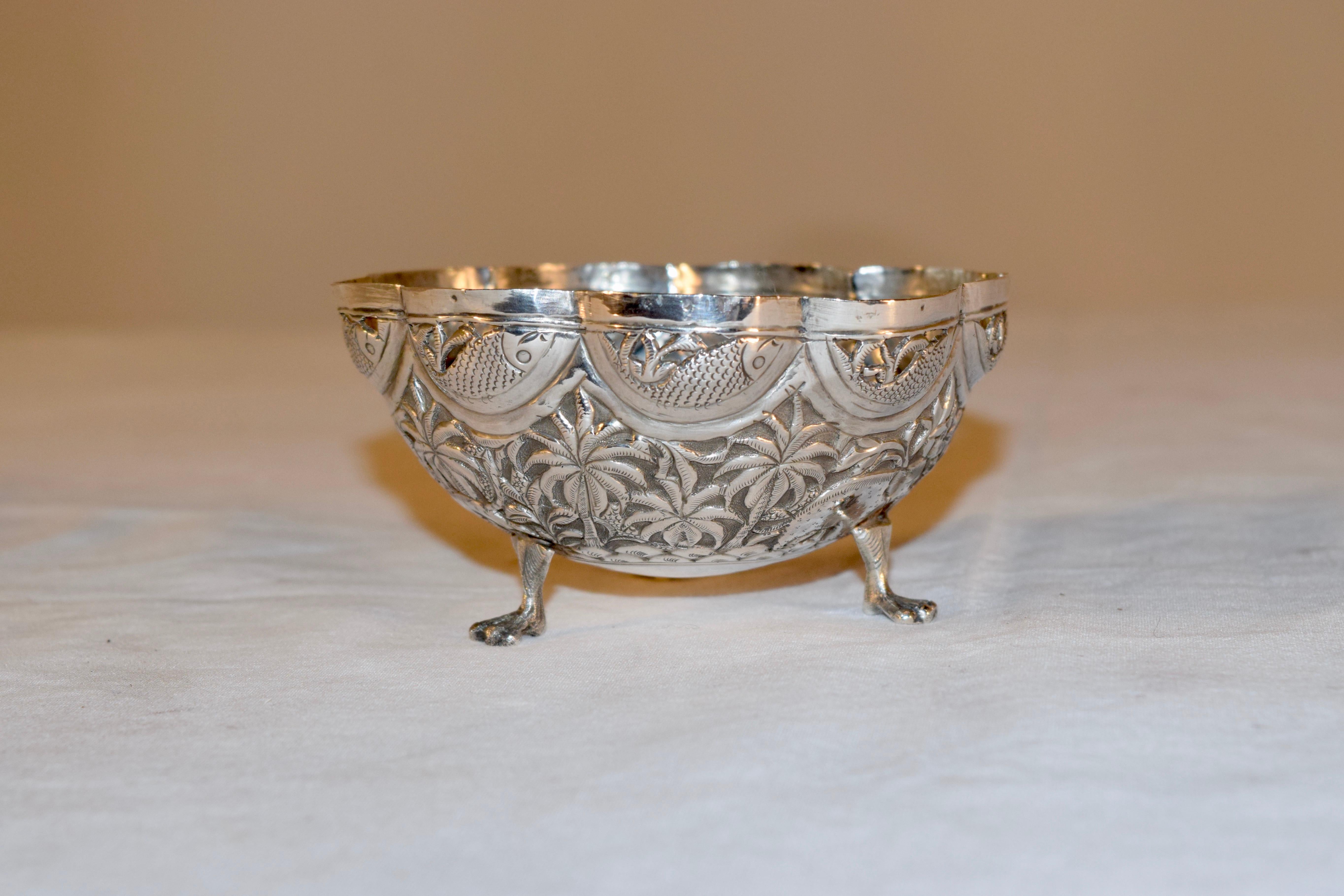 19th century handcrafted antique Anglo-Indian silver bowl with repoussé depicting animals, fish and palm trees on three paw feet. The bowl is pierced around the fish near the rim.