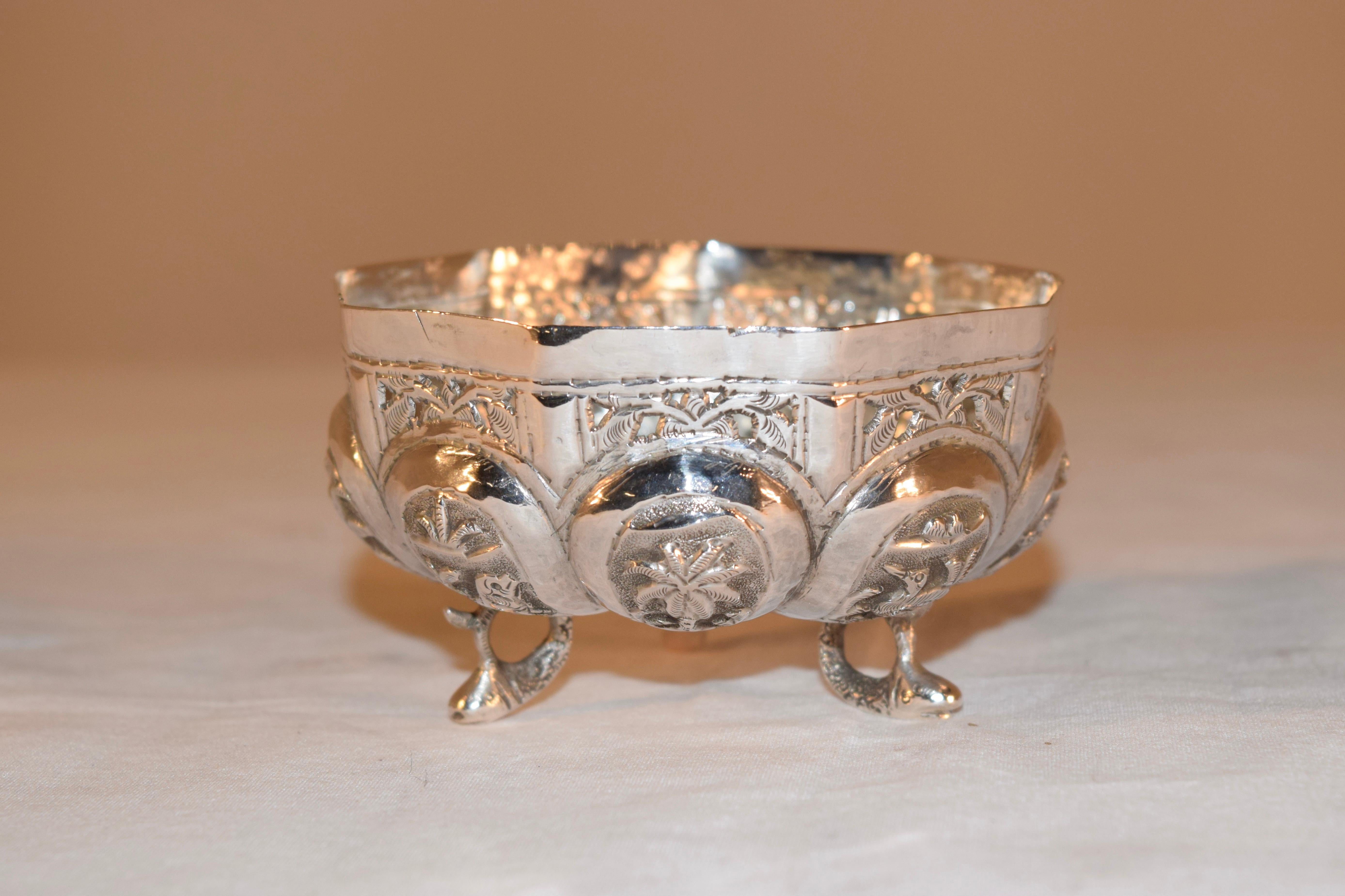 19th century Anglo-Indian silver bowl with a rounded melon shaped base decorated with medallions which have pictures of animals and palms, under a rim which has lovely reticulated foliage. Supported on three fish feet.