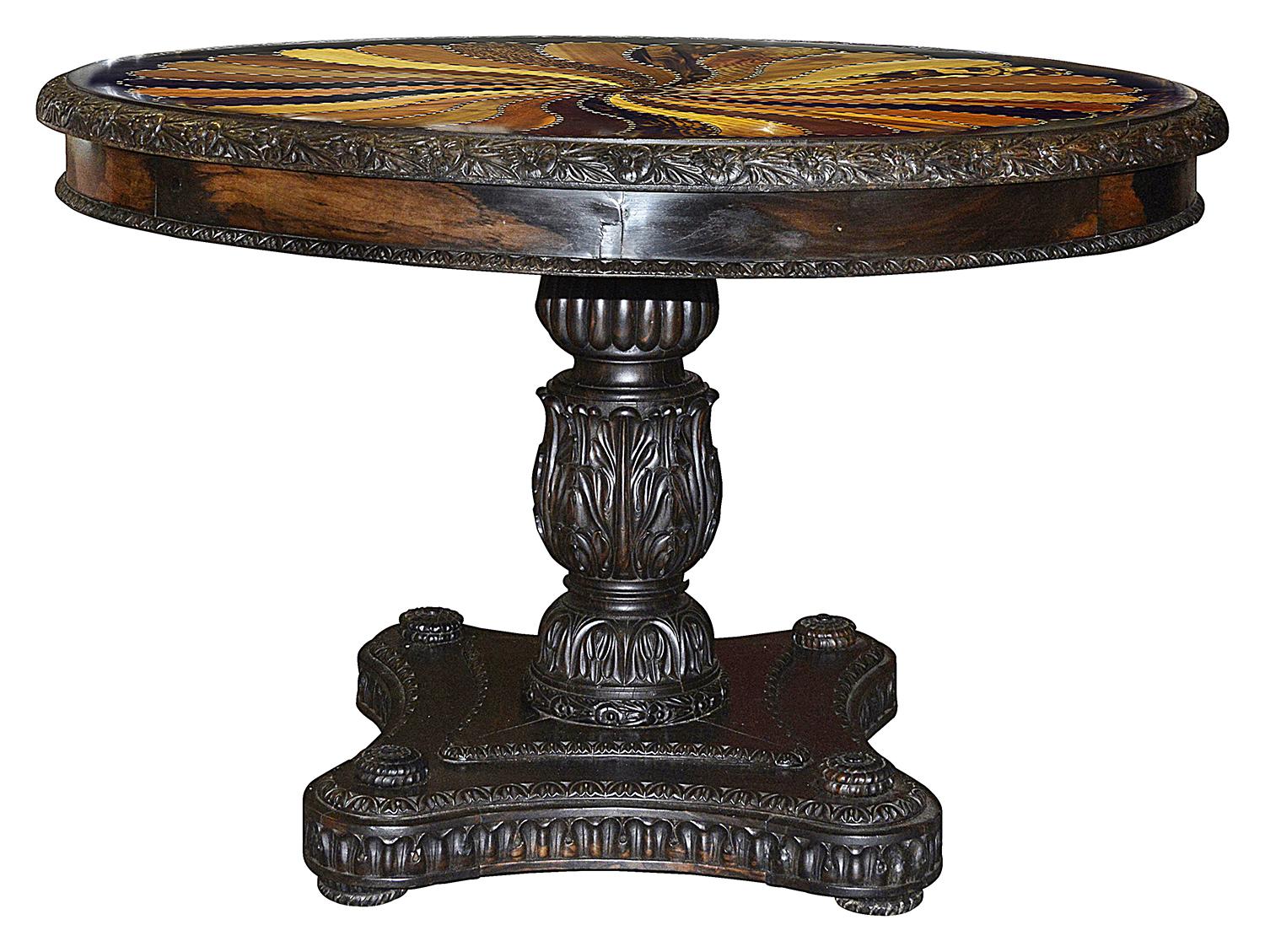 A wonderful and rare mid 19th century Ceylonese specimen native wood centre table, set in an Ebony boarder, the base having hand carved foliate and motif decoration. The top having with radiating veneers of Satinwood, Ebony, Rosewood, Pol-Coconut,