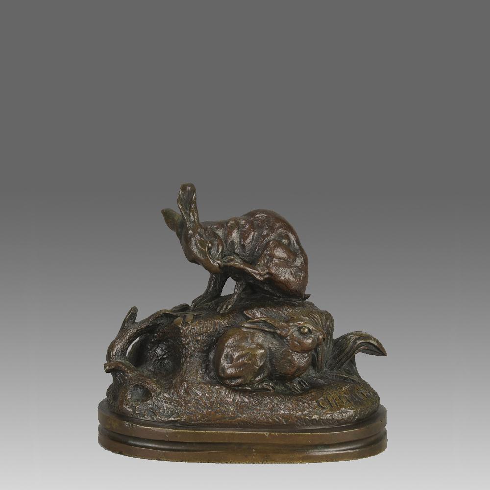  Eine charmante Bronzestudie aus dem frühen 20. Jahrhundert, die zwei Kaninchen in ihrer natürlichen Umgebung zeigt. Das eine Kaninchen genießt das Kratzen auf der Spitze eines Hügels, während das andere Kaninchen in einem versteckten Bereich am Fuß