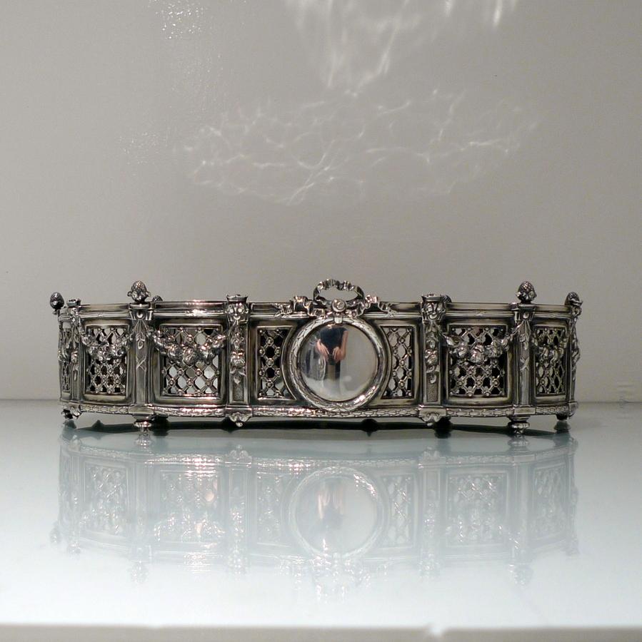 A beautifully designed 19th century silver jardinière decorated with pierced lattice work walls and stylish overhanging floral garlands which are sandwiched between ornate pillars for visual highlights. The plain formed inner dish is detachable.

