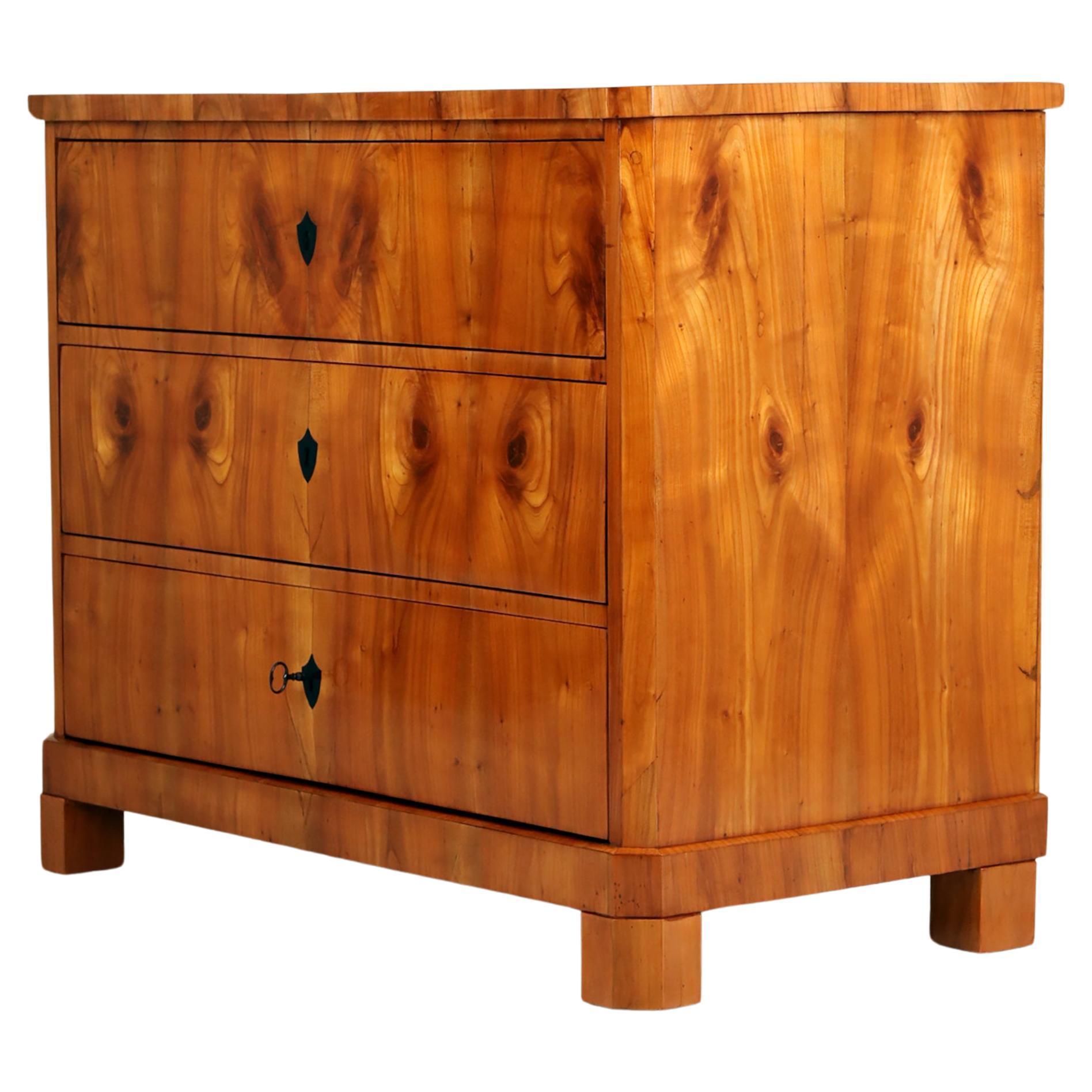 Biedermeier Kommode, Süddeutschland um 1820

Die Kommode mit drei Schubladen steht auf vier massiven Blockfüßen. 
Kirschholz furniert auf Weichholz. Durchgehende Maserung vom Boden bis zur Deckplatte. Gespiegelte und streng symmetrische Ausführung.