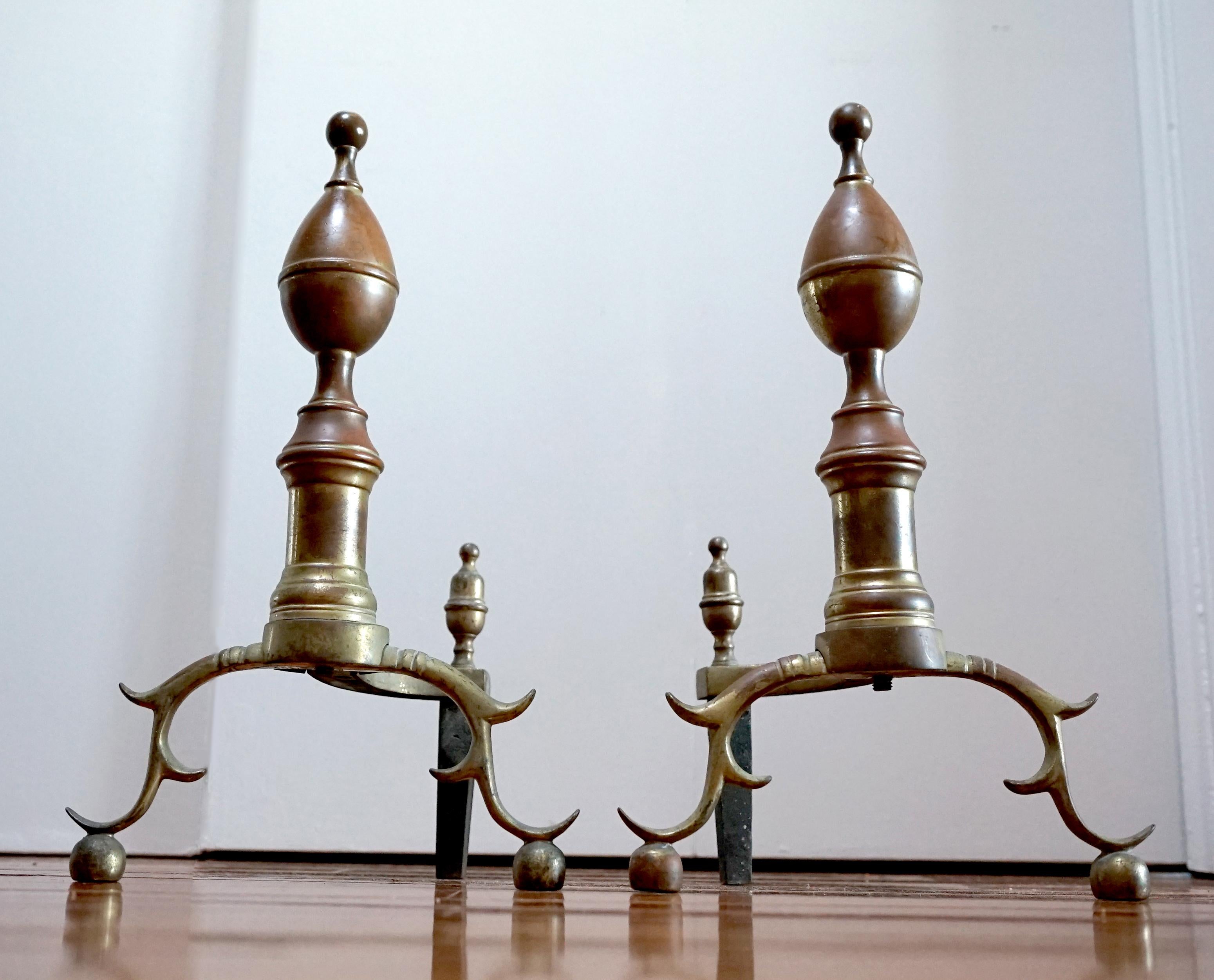 
An antique pair of classic American brass and iron lemon-top andirons create a beautiful silhouette in front of a cozy fireplace.
These are from the latter part of the 19th century, and they are in good condition.  
Each with spherical finial over