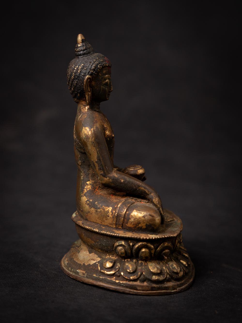The antique bronze Nepali Buddha statue is a captivating and spiritually significant artifact originating from Nepal. Crafted from bronze and adorned with fire gilding in 24-karat gold, this statue stands at 12.8 cm in height and measures 9.8 cm in