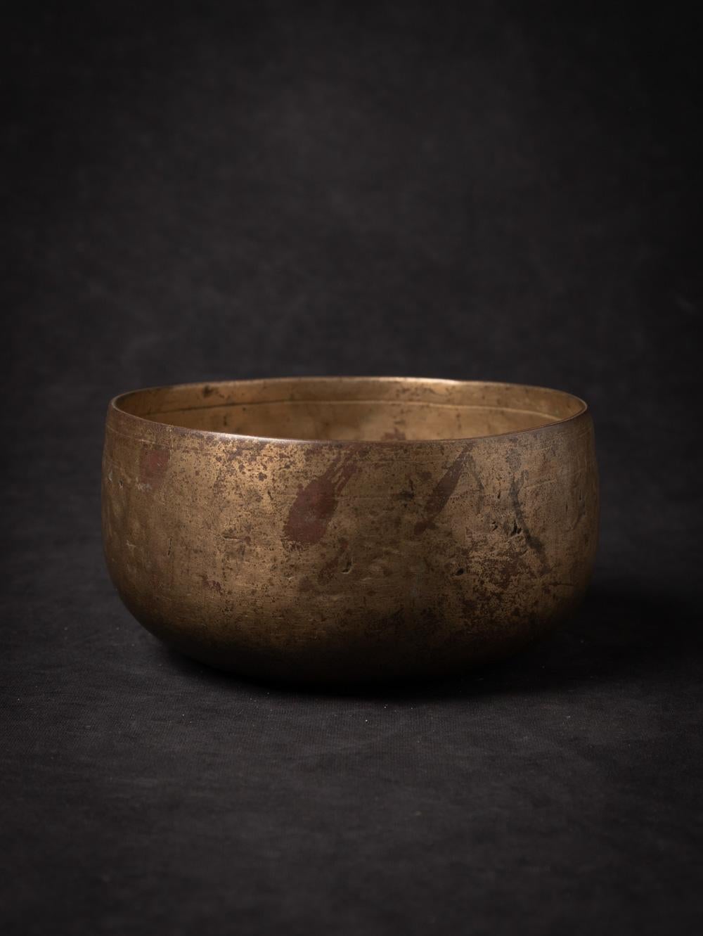 This antique bronze Nepali Singing bowl originates from Nepal and dates back to the 19th century. Crafted from bronze, it showcases the rich cultural heritage of Nepal. The bowl stands at a height of 9 cm with a diameter of 16,9 cm, making it a