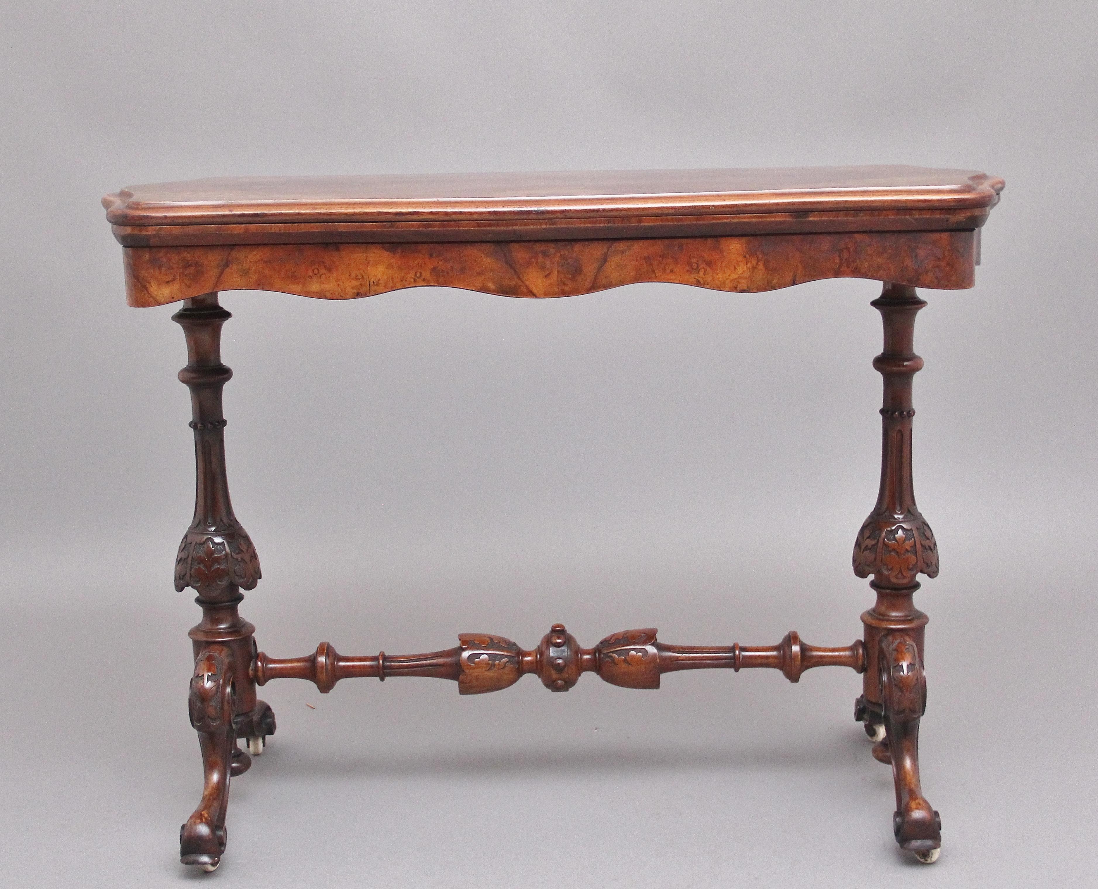 19th century burr walnut folding card / games table, having a nice figured top with a moulded edge and decorative floral inlay, the hinged folding top which open out to reveal a green baize lined playing surface and compartment space, supported on