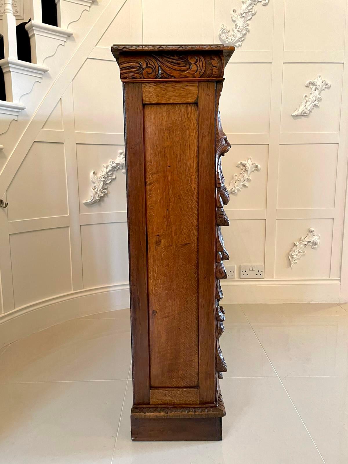19th century antique carved oak open bookcase having an oak top with a delightful carved frieze, paneled oak sides, quality oak supports expertly carved with bird heads, fruits, flowers and oak leaves, two adjustable shelves standing on a plinth
