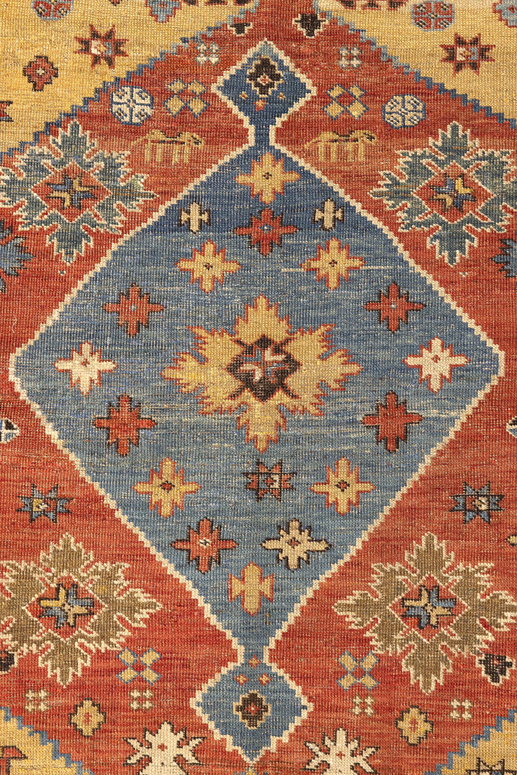 Shirvan – Southeast Caucasus

This cheerful Shirvan features a red medallion with a sky-blue diamond over the yellow field. The entire area of the rug is filled with staggered polygons, stars and other geometric figures that illuminate the carpet