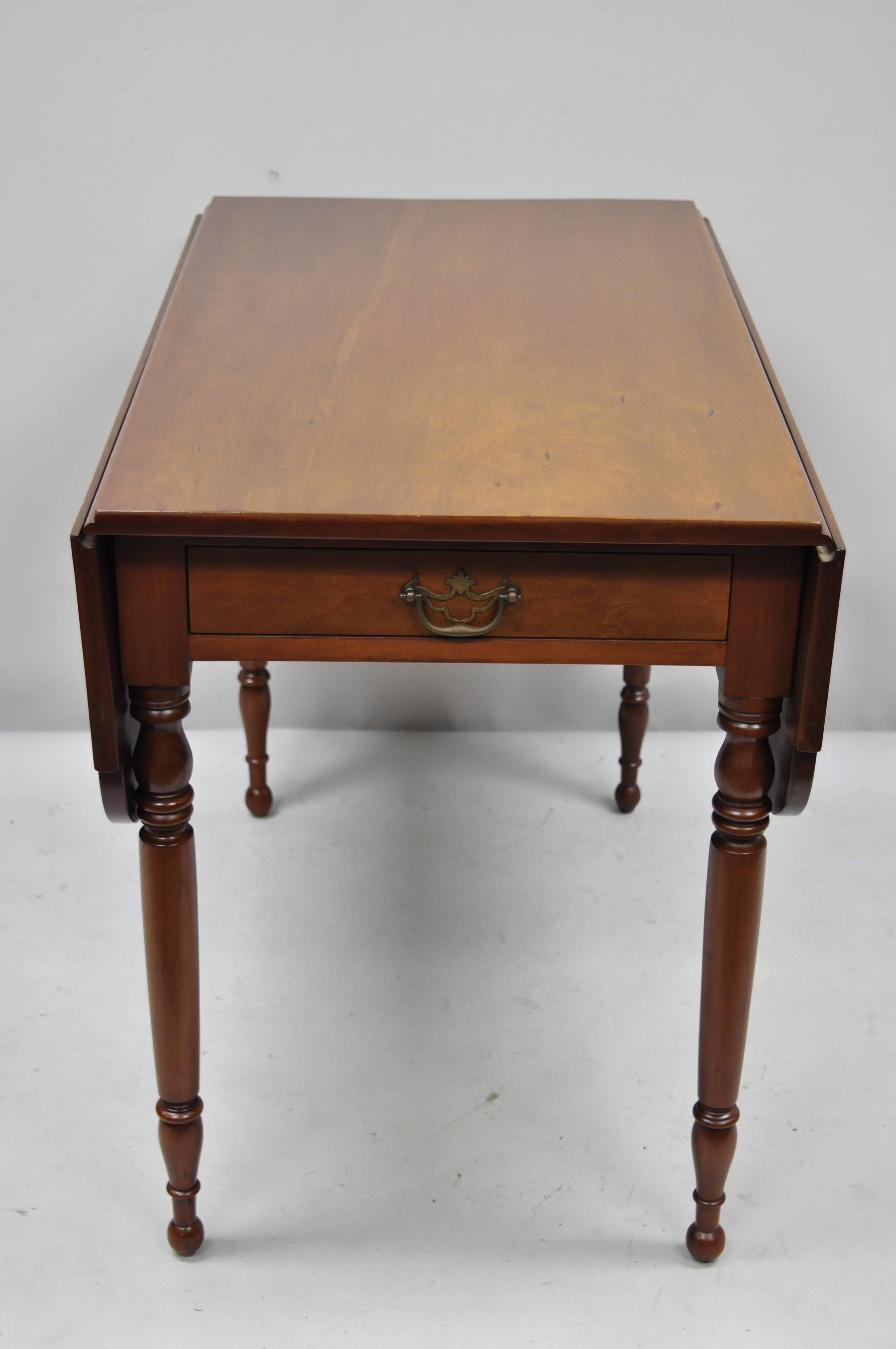 19th Century Antique Cherry Wood American Colonial Drop Leaf Pembroke Table. Item features turn carved legs, solid wood construction, beautiful wood grain, nicely carved details,1 dovetailed drawer, solid brass hardware, very nice antique item.