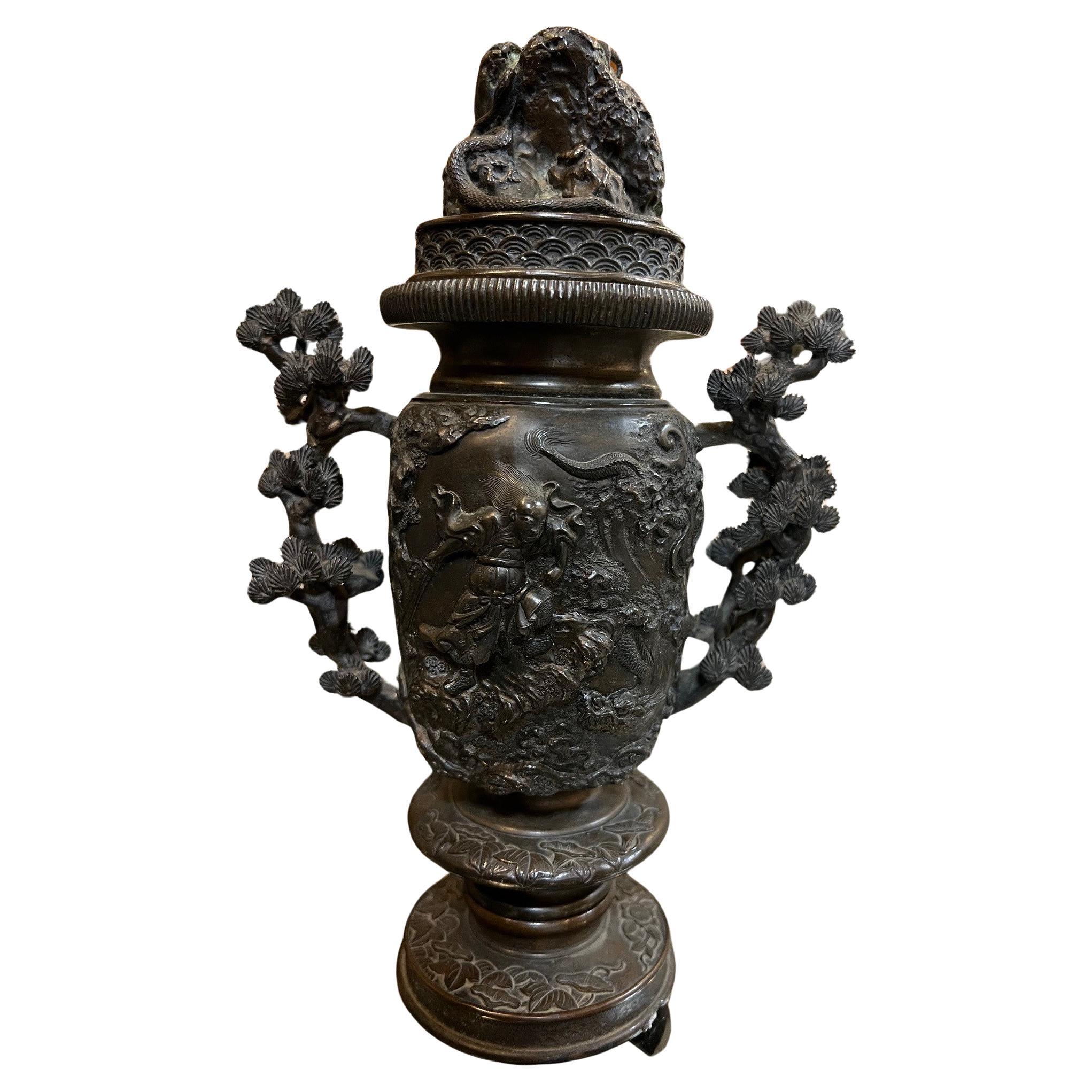 A bronze censer or also known as a incense burner from the 19th century. This incense burner has great detailing with handles in the shape of bonsai trees. The center section has a eagle flying over snakes on one side and a warrior holding a sword