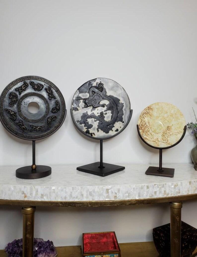 An exceptional antique trio of hand carved Ming Dynasty Chinese bi disks, dated to the late 19th century, featuring three distinctive circular stones with intricate finely detailed relief work, presented in contemporary stands. circa 1880

Found