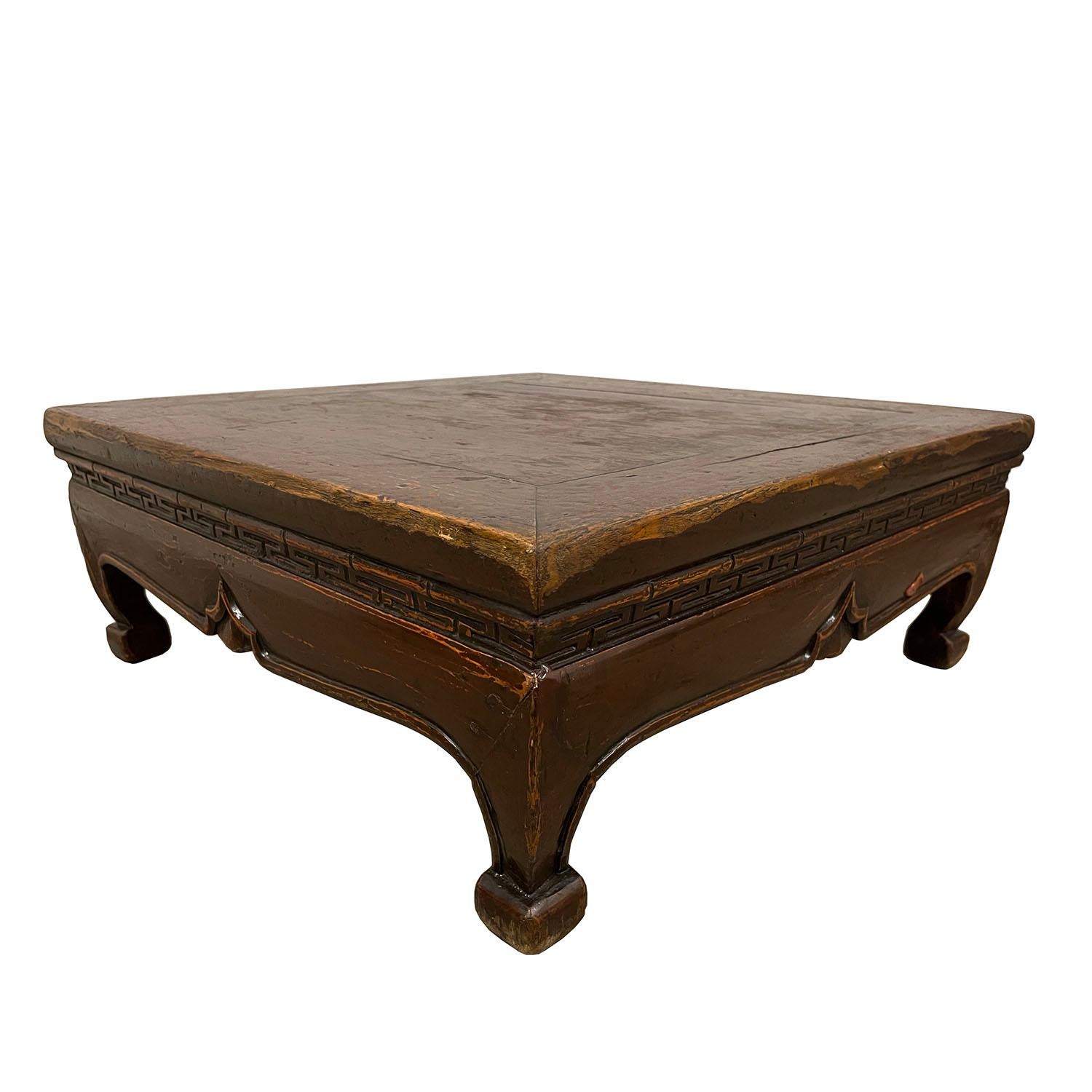 This antique Chinese carved low coffee table is made of solid Elm wood with brown lacquer finished. It has narrow carved waist with traditional Chinese folks arts design. Very smooth to touch and full of patina. From the pictures, you can see some