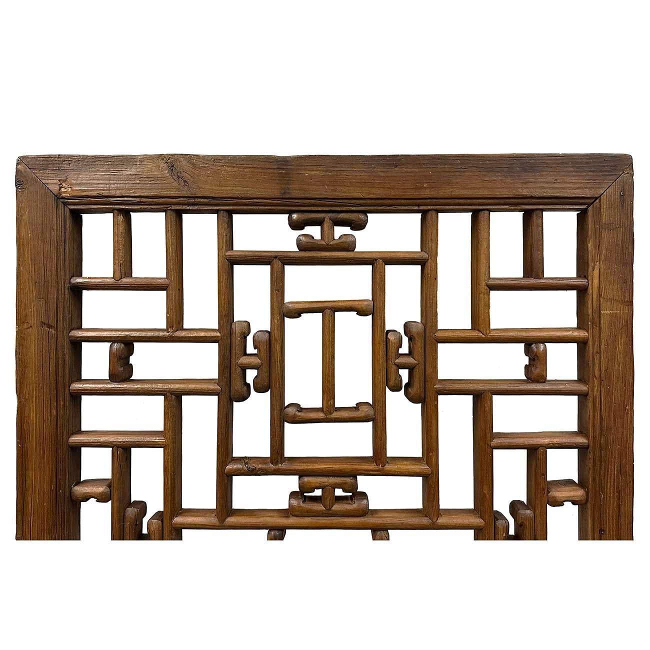 Ce grand panneau de fenêtre intérieure en bois d'orme sculpté, datant de la fin du XIXe siècle et de la dynastie Qing, avec motif ajouré, a été créé en Chine pendant la dynastie Qing, dans les dernières années du XIXe siècle. Ce panneau de fenêtre