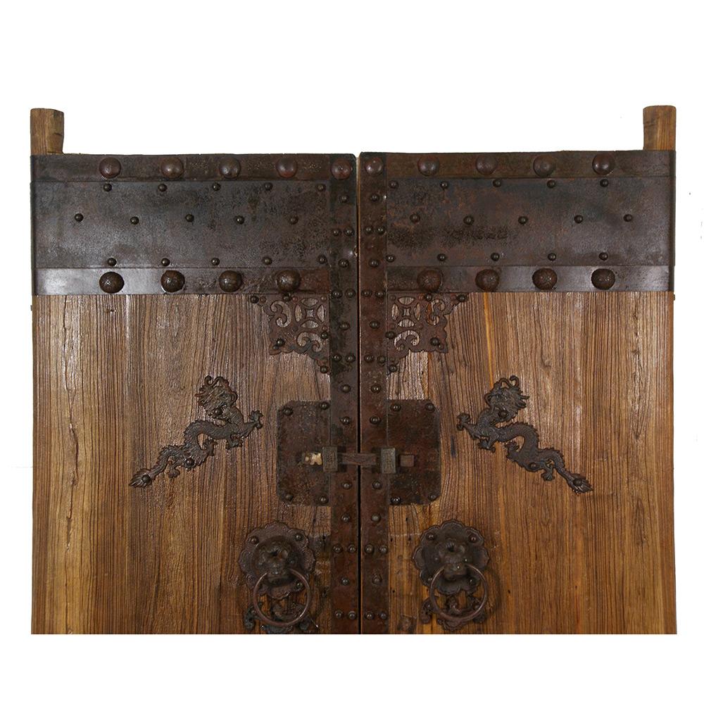 This is a pair of Chinese antique massive Court Yard Door panels. They were made of Elm wood, very heavy, solid and sturdy. It features metal armored around the edges forming unique patterns all over the doors. It has 2 antique heavy duty hand