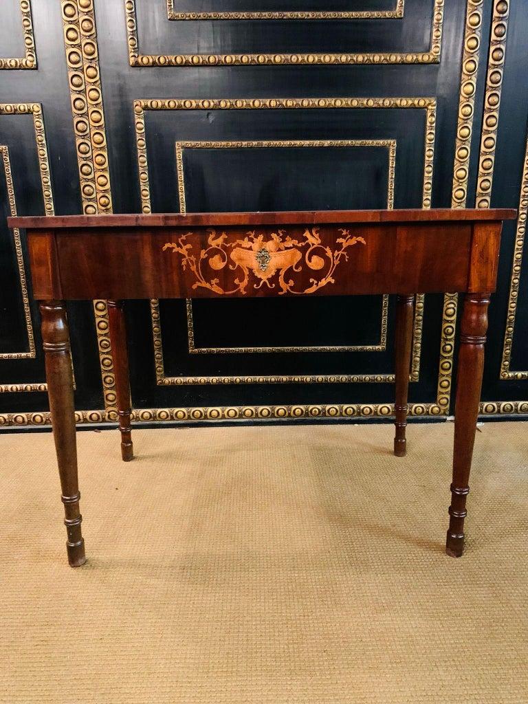 Scrivania classica Biedermeier del XIX secolo Legno massiccio e impiallacciatura di mogano. Piano d'appoggio rettangolare longitudinale con un cassetto, telaio tagliato per favorire le gambe e gambe quadrate che si assottigliano verso il basso.