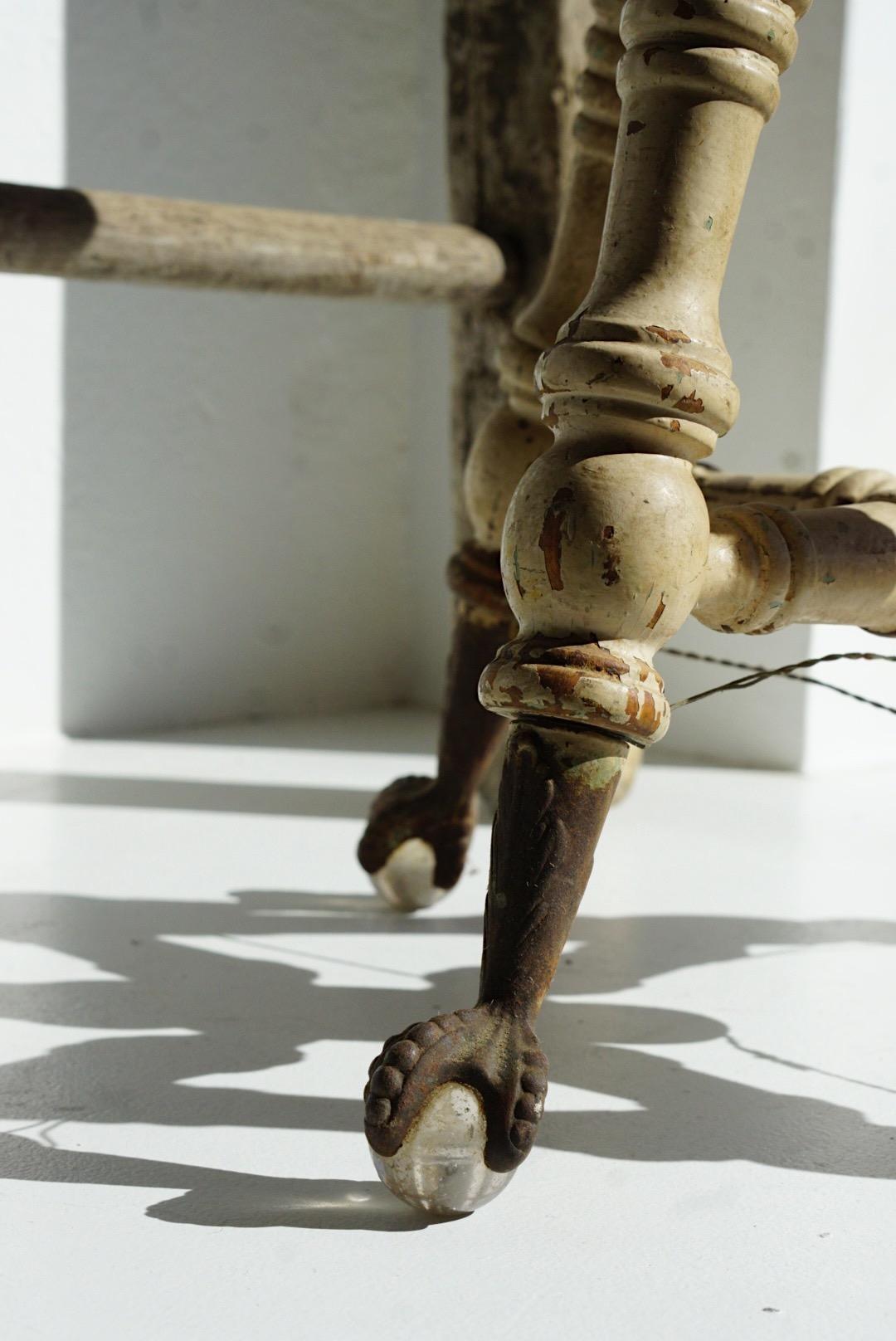 Antique Piano stool that features cast iron threaded swivel seat, 4 turned legs and turned center support with glass ball beaded claw feet. The seat is missing a screw. Sold as is.