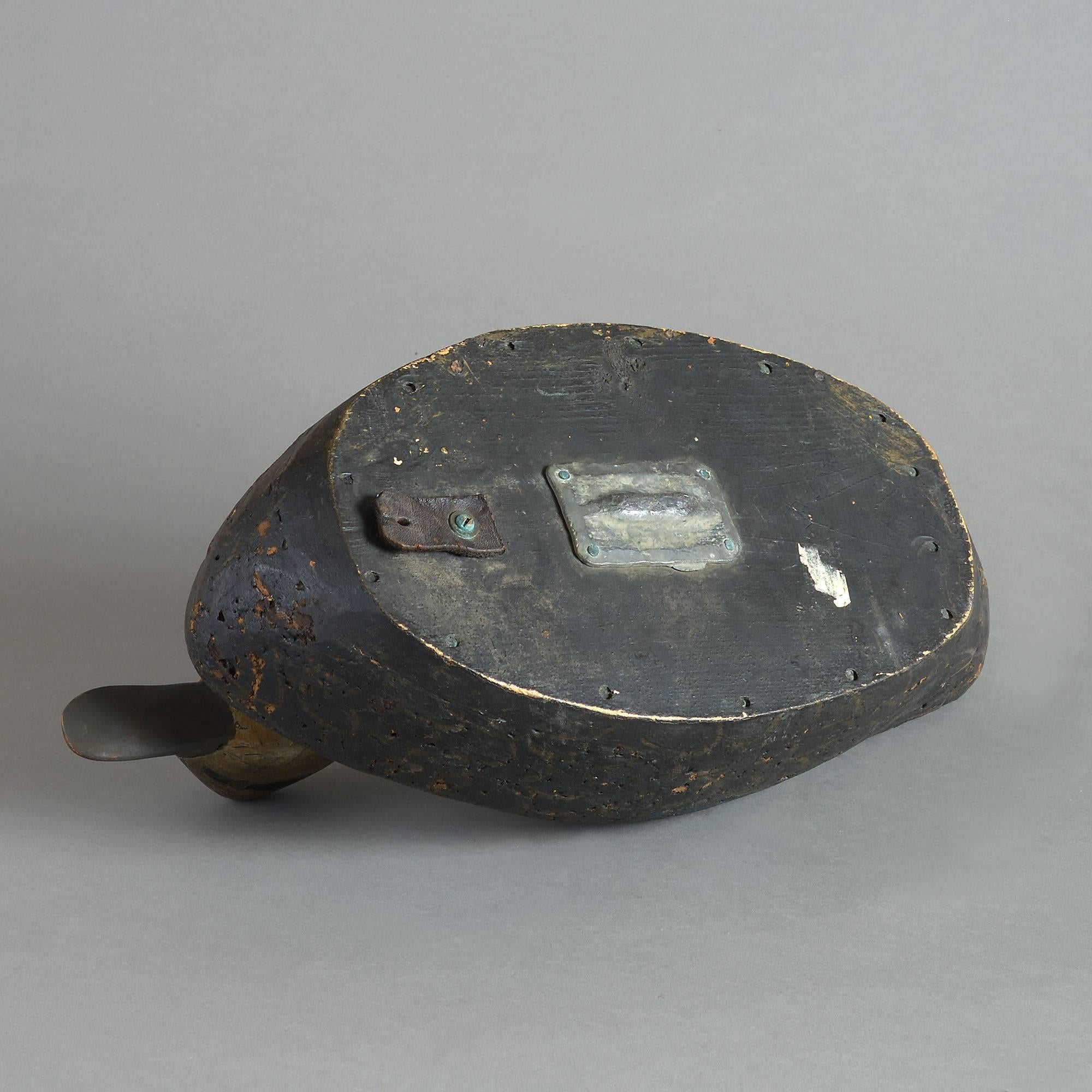 A rare 19th century decoy duck, the head and body realistically carved and subtly painted. Retaining its original weight.