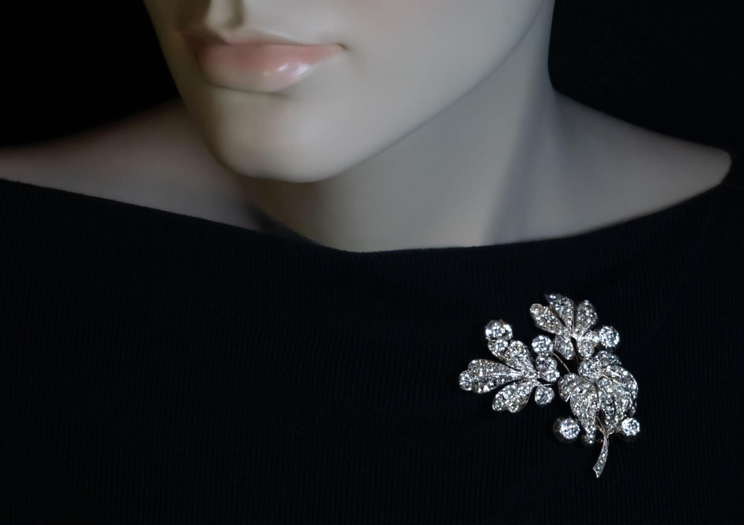 Circa 1840s  This large antique early Victorian era brooch is naturalistically modeled as a spray of flowers. The brooch is superbly crafted in silver-topped 14K gold (front – silver / back – gold). Six flower heads are set with faceted round rock