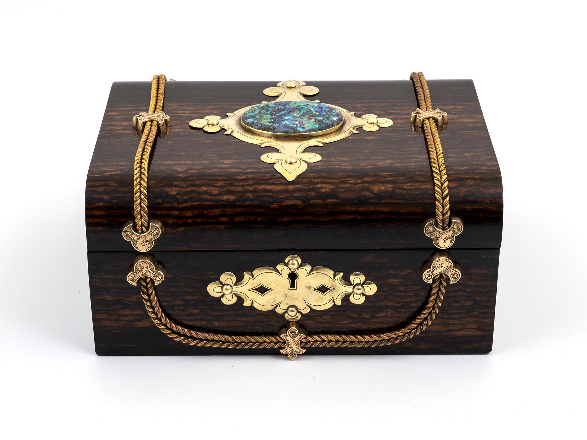 An exquisite antique dome-top jewellery box that embodies timeless elegance and superb craftsmanship.

The exterior of the box is veneered in exotic Coromandel, showcasing a captivating Abalone medallion at the centre of the lid. The medallion is