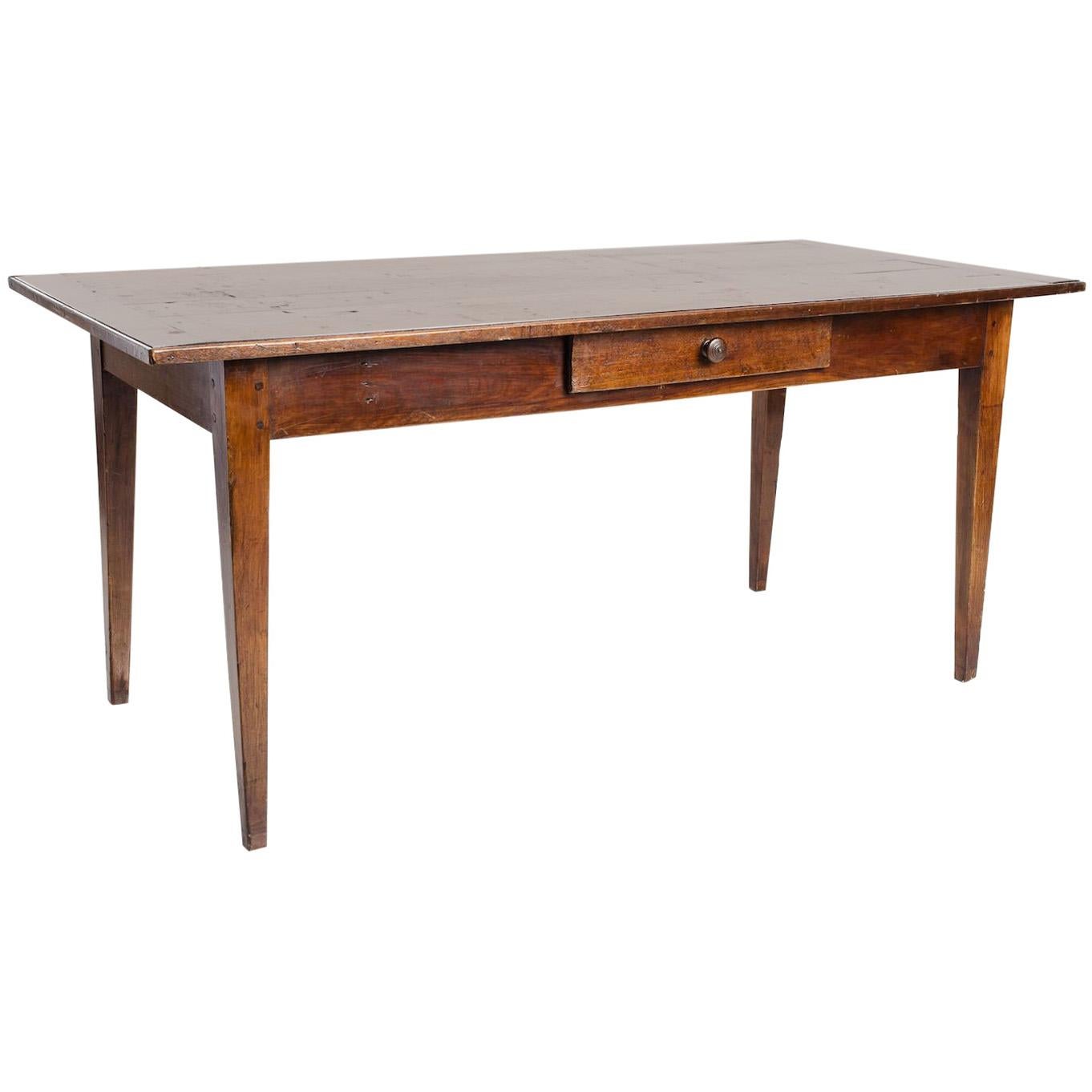 Handsome antique wood table with single drawer, made in England, circa 1860. Minimal silhouette features straight lines and tapered legs. Made from cherrywood, the table has a smooth, satin surface with beautiful age and patina. A functional drawer