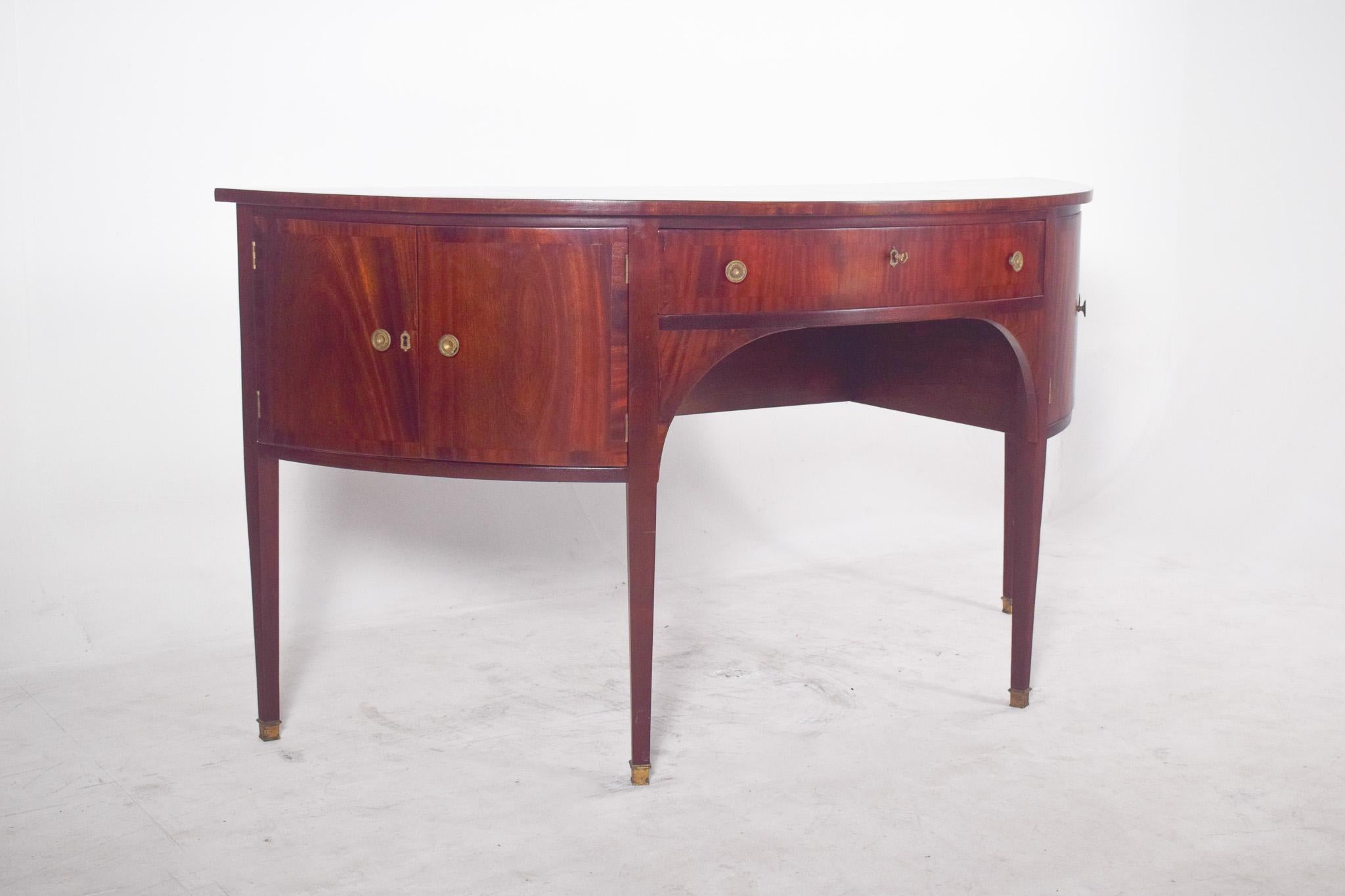 Empire sideboard in the shape of a half-moon. With a varnished finish in a reddish tone, it shows off precise and elegant joinery. The curved side doors follow the contour of the furniture, revealing discreet and functional internal compartments,