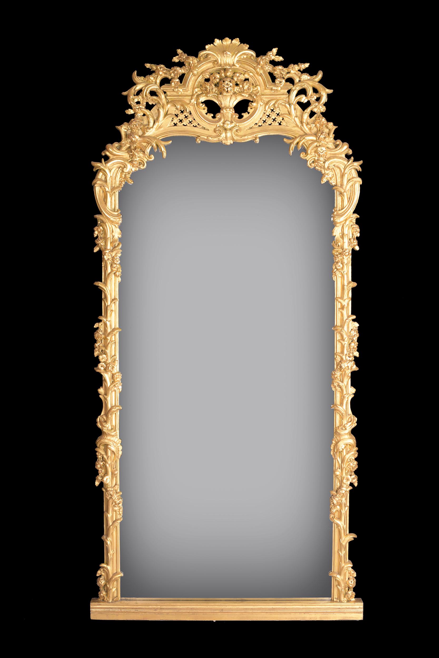 Ein sehr schöner, großer und attraktiver vergoldeter Spiegel in gewölbter, rechteckiger Form, umgeben von einem kunstvollen Blatt- und Rankenwerk, überragt von einem Rankenwerk und einer zentralen Muschel, die auf einer Plattform steht.

Um