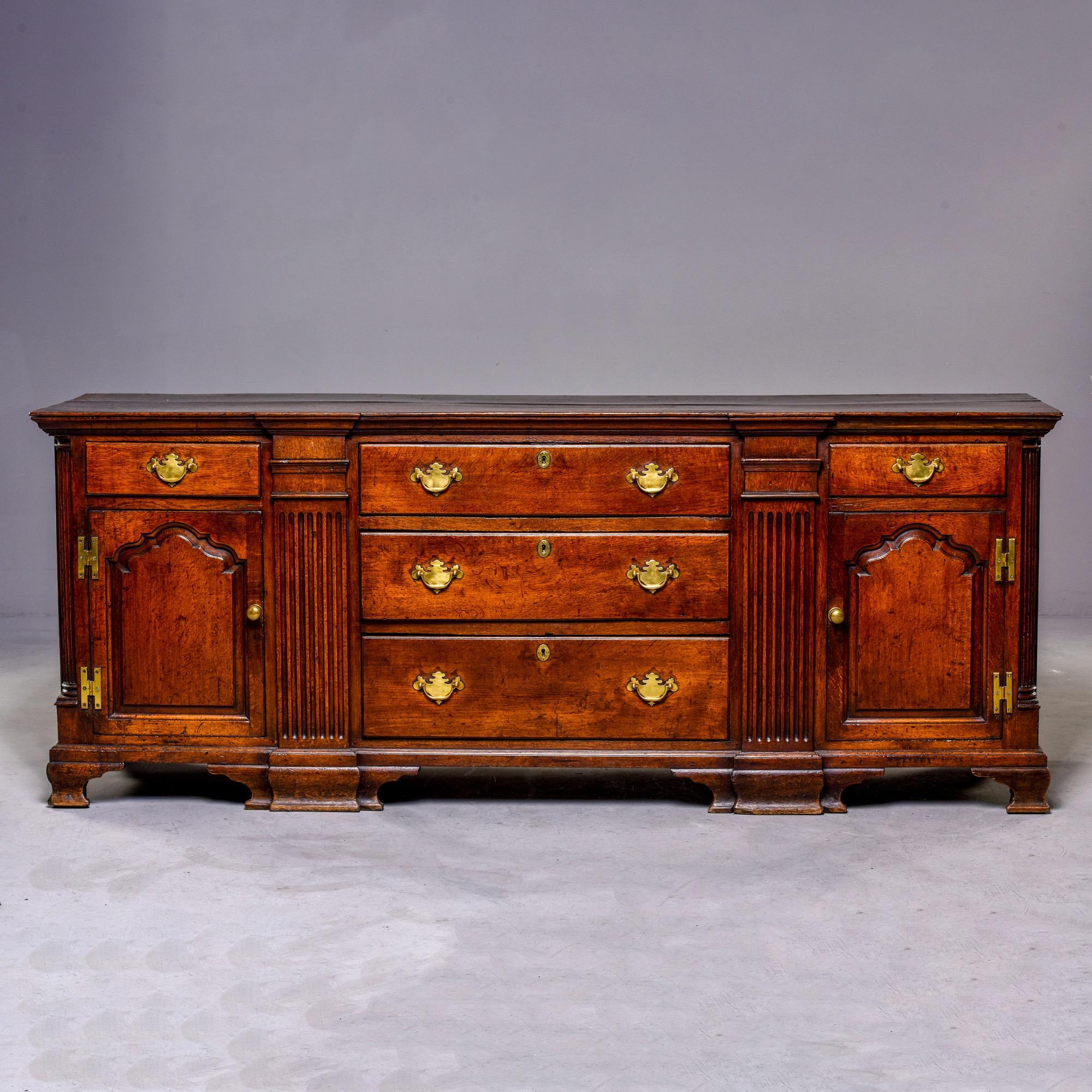 Extra large English oak chest with all original finish and hardware, circa 1840s . Chest features a center stack of three drawers flanked by cabinets with hinged doors topped by a drawer. Solid construction with dovetailed drawers and decorative