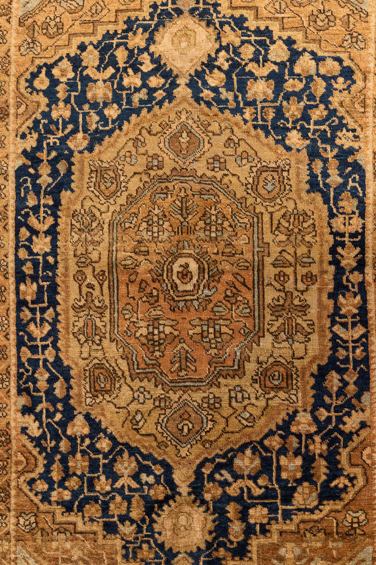Farahan Sarouk – West Persia

This magnificent Farahan features an intricate design with geometric and floral patterns. The predominant colours are dark blue, gold, and orangey beige shades. The centre of the rug showcases an oval medallion adorned