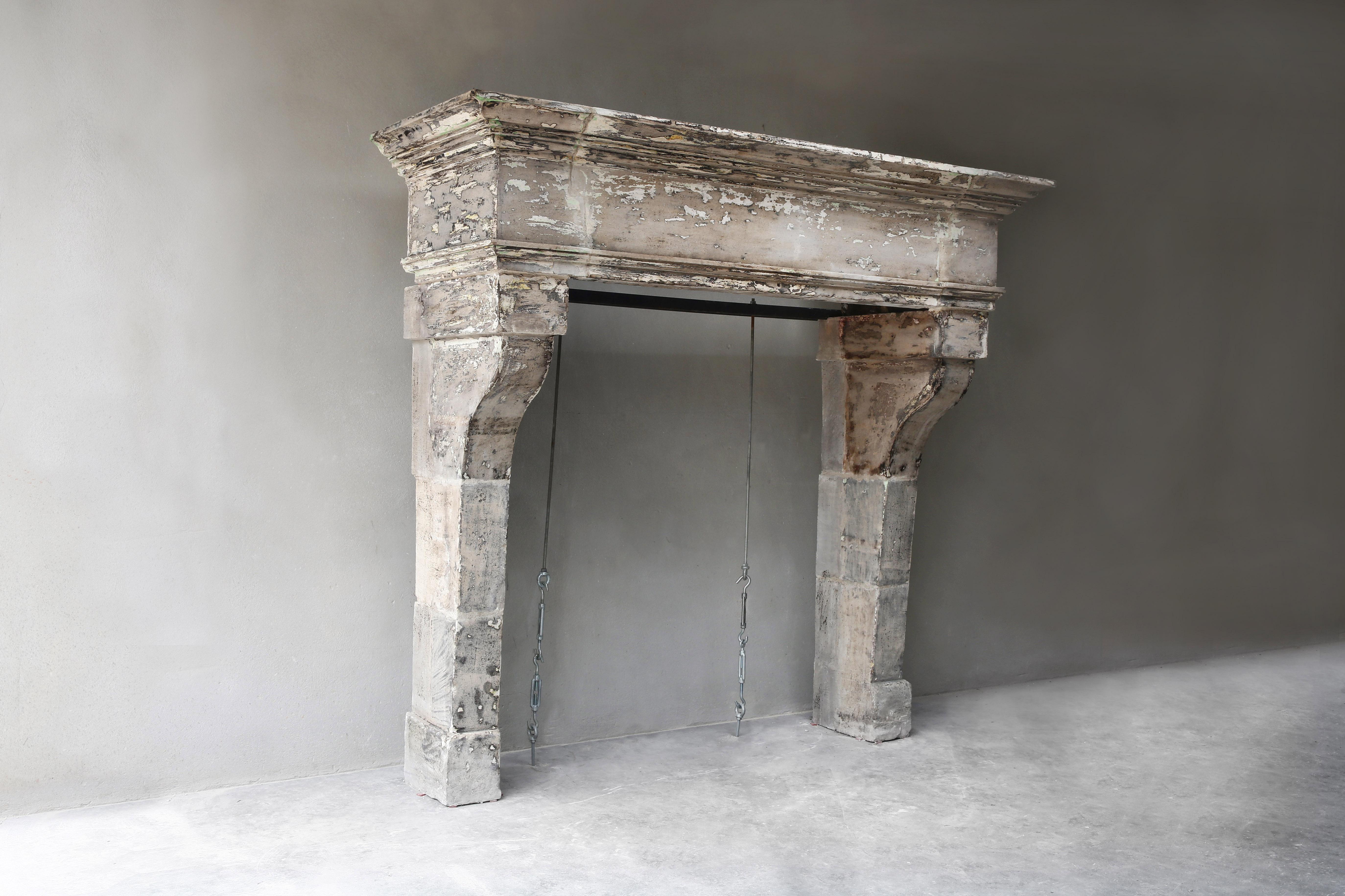 Beautiful antique French limestone fireplace from the 19th century! This fireplace is in the style of Louis XIII and is characterized by its soberness and broad top. The broad top and the lines give allure and character to this fireplace. A