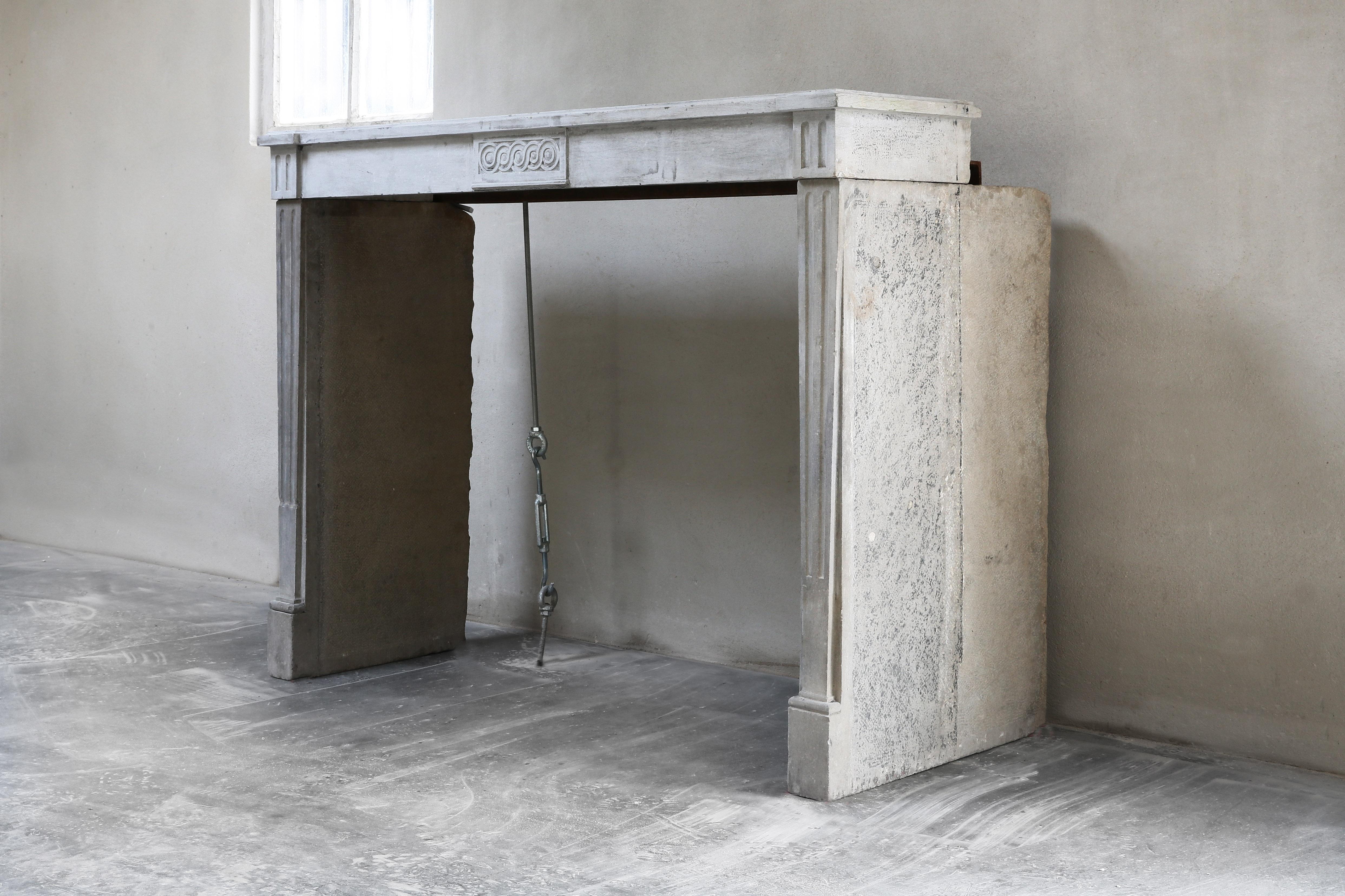 Beautiful elegant antique fireplace with straight shapes. This fireplace dates from the 19th century and is in the style of Louis XVI. This beautiful gray color provides a serene appearance. A fireplace that fits both in a modern interior and in a