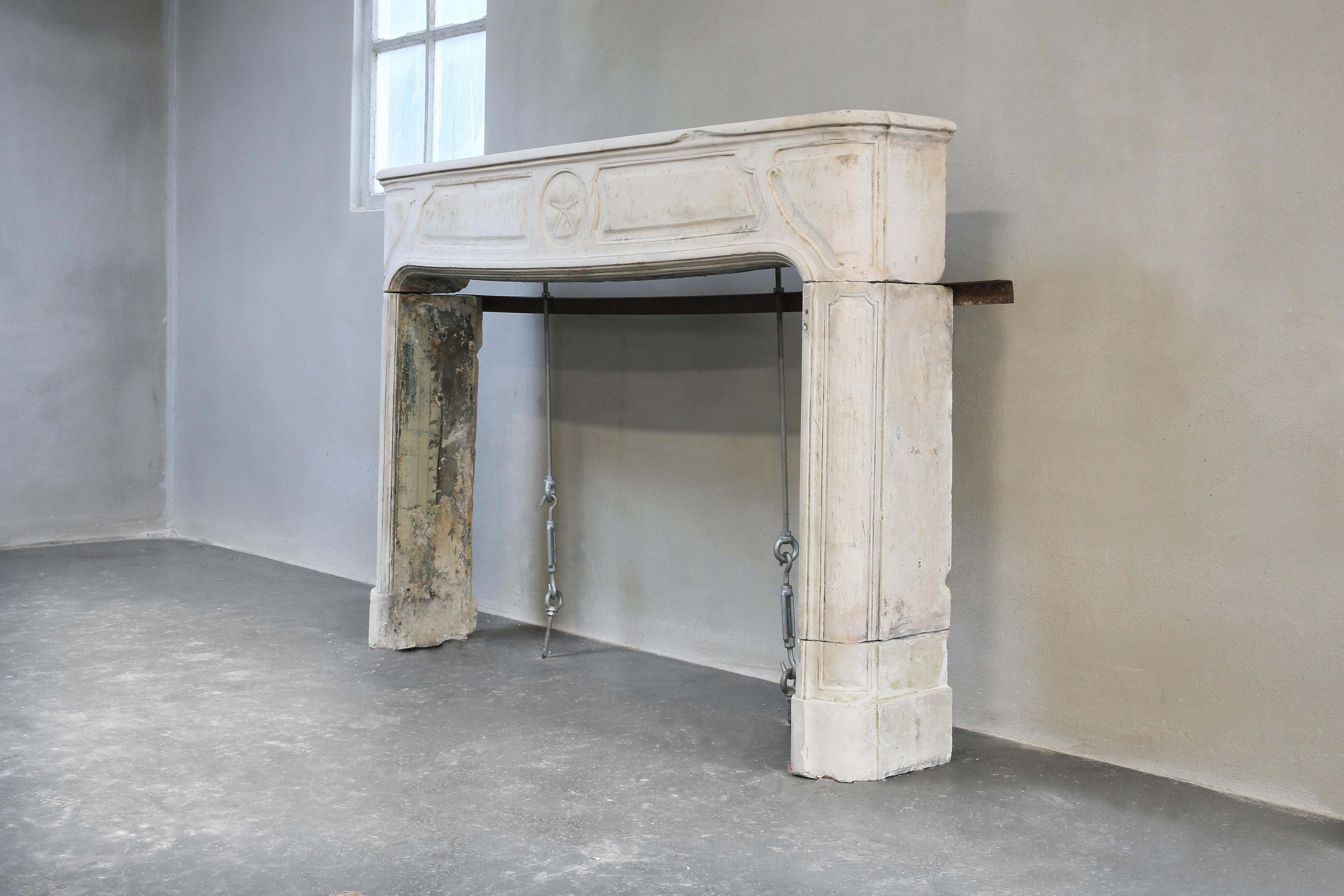 Beautiful antique fireplace from the 19th century in the style of Louis XIV. A fireplace with ornaments in the front part and beautiful lines on the legs! The dimensions are also applicable for many interiors. The light color of the mantle provides