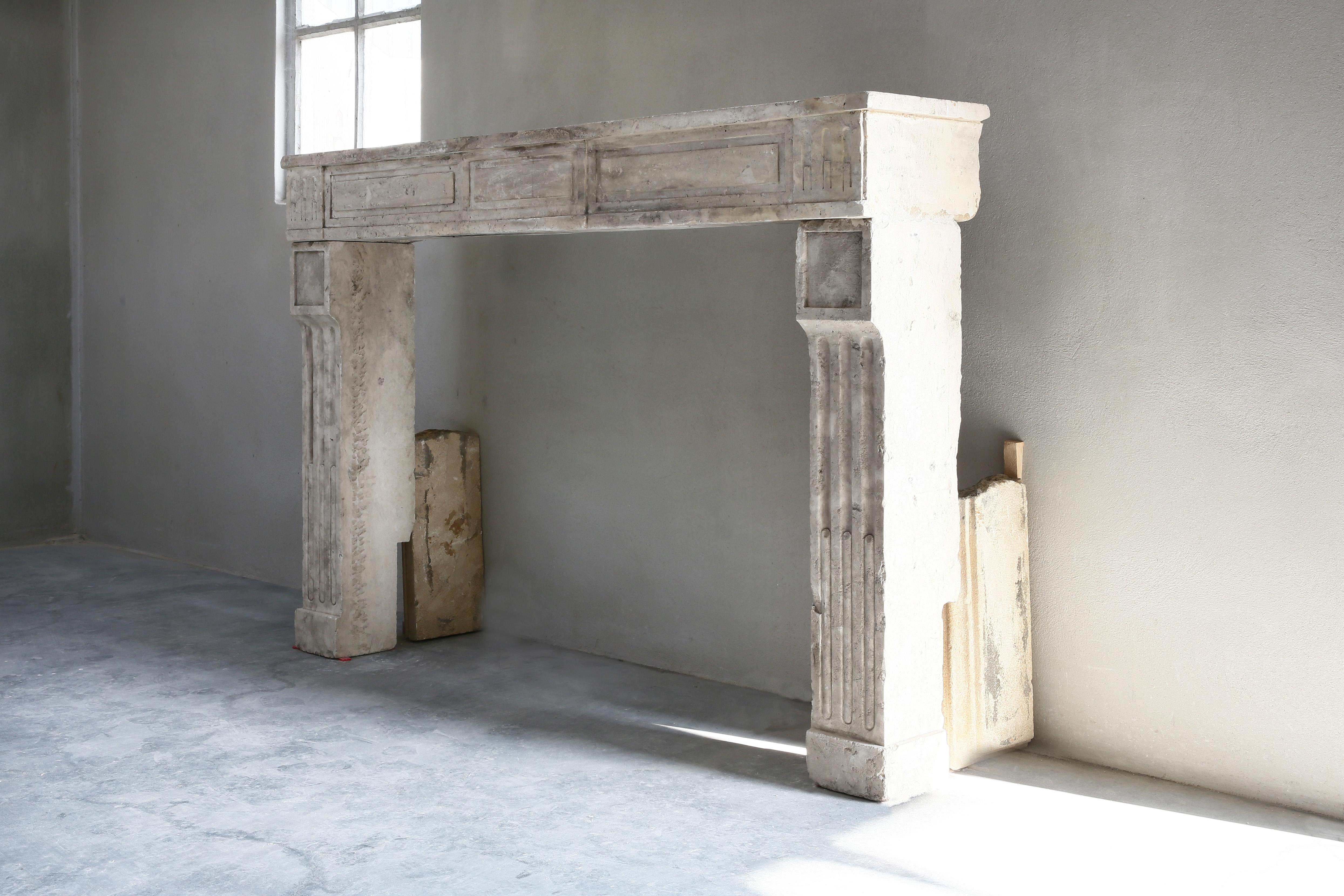 Beautiful French limestone antique fireplace from the 19th century. This fireplace is in the style of Louis XVI. It is a straight model with beautiful lines and cannelures on the legs. The color scheme is warm and adds atmosphere to your home.