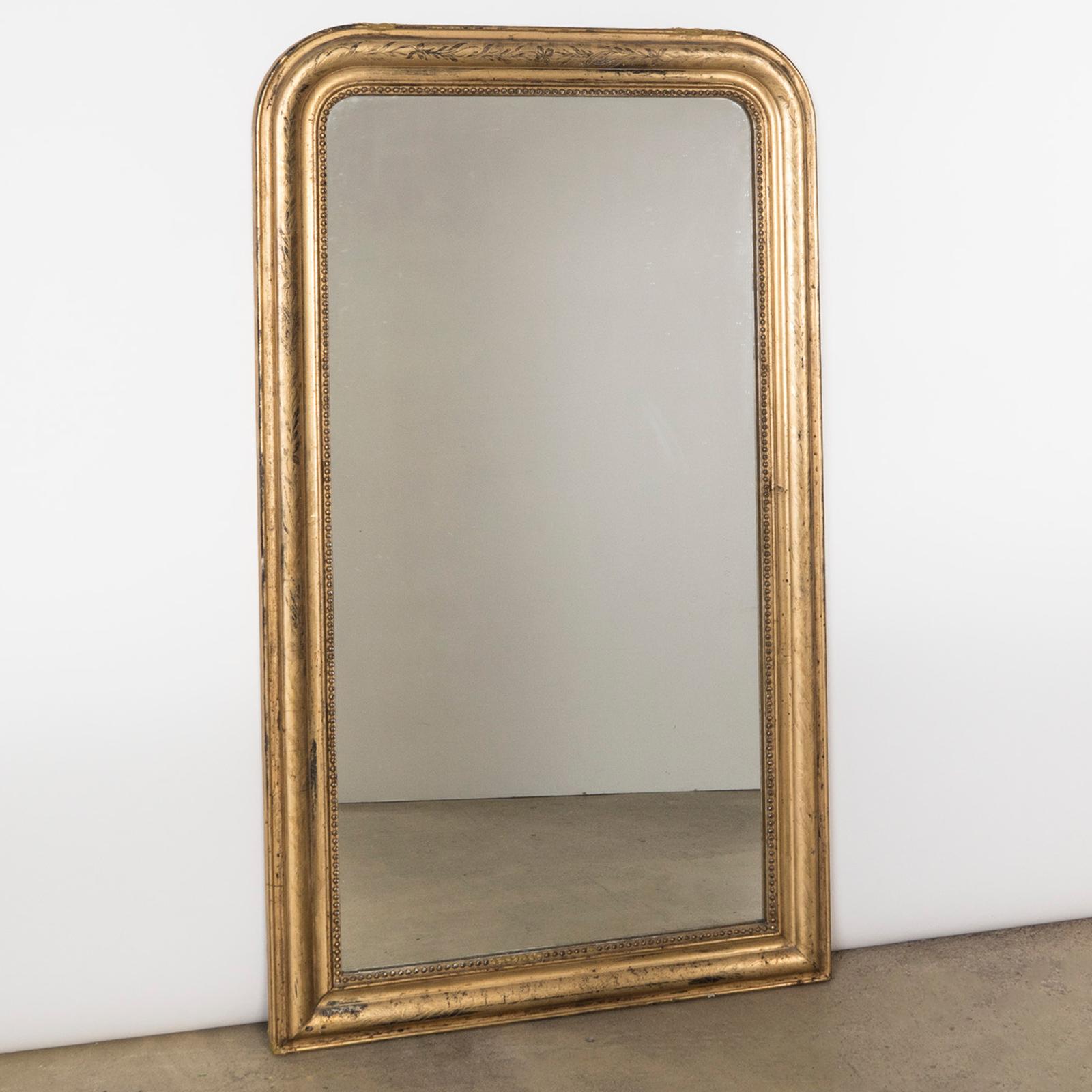 Antique French 19th century Louis Philippe style gold gilt mirror intricately etched with an intertwining design of ivy leaves and flowers and its inner rim edged with a classic 'string of pearls' motif.

This beautiful antique French gold gilt