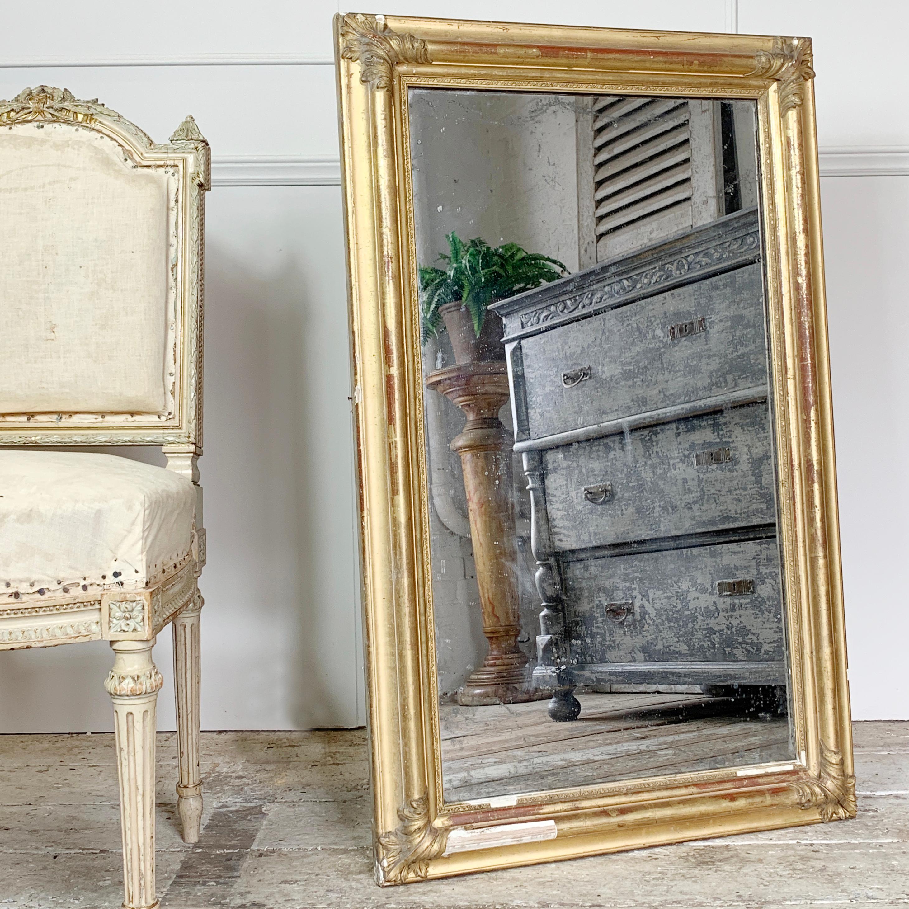 19th century antique French gilt mirror. Beautiful aged gilt and gesso frame. Foxed mirror plate in places
Original wooden back boards

Measures: 97cm height, 60cm width, 6cm depth
mirror glass 81cm x 45cm

Approximate weight 10kg
Some historical