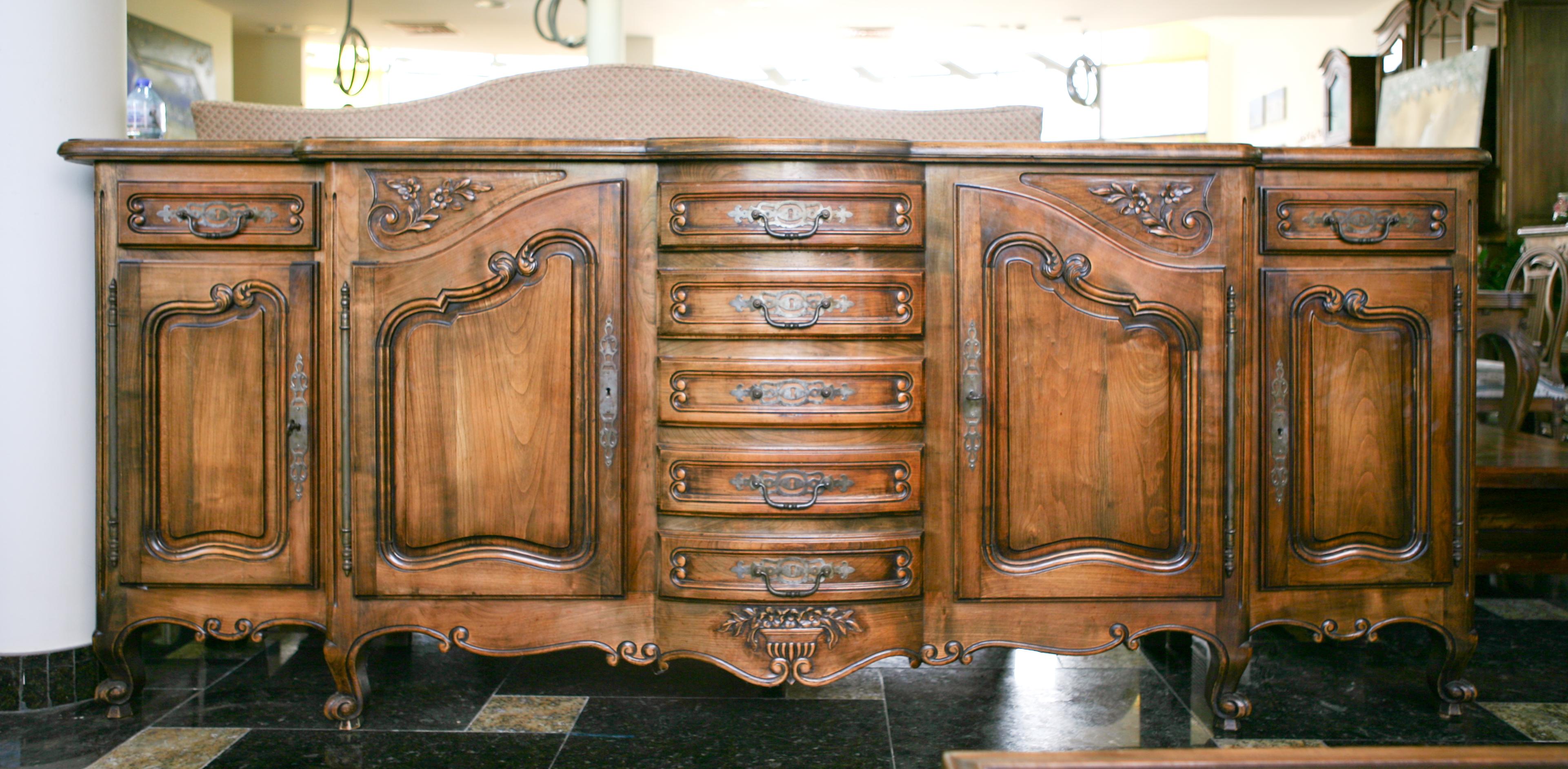 Un beau buffet français ancien de style Louis XV, vers 1870.
Fabriqué en chêne massif avec des courbes et des sculptures luxueuses. Le plateau en marqueterie présente une forme vive et ondulée sur le devant. Cinq tiroirs superposés sont placés