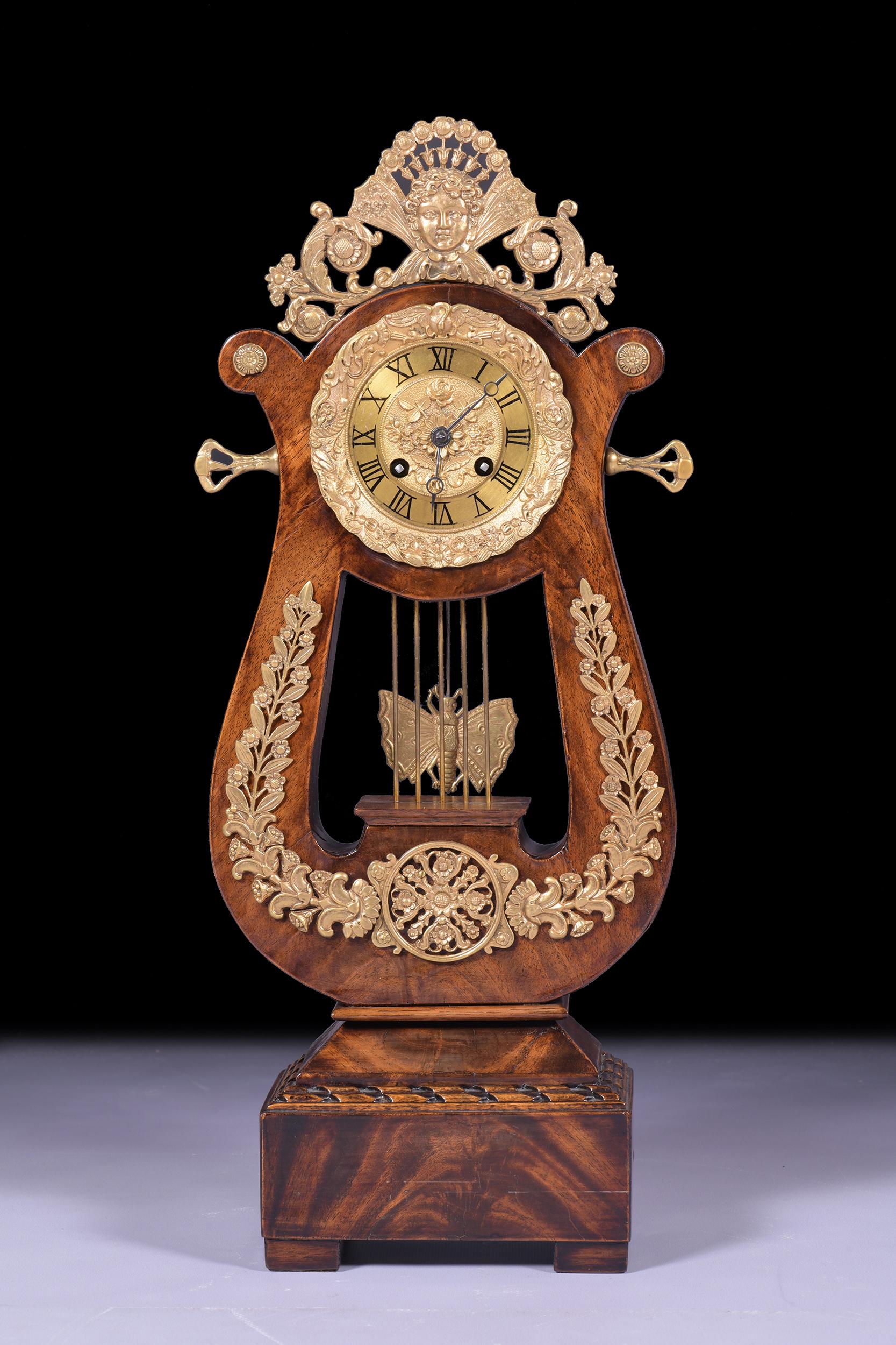 A very fine and attractive French Lyre mantel clock by Ponds of Paris in ormolu mounted mahogany. The clock, set on a rectangular base sitting upon four ball feet. The arms of the lyre in well figured mahogany and with applied ormolu mounts of