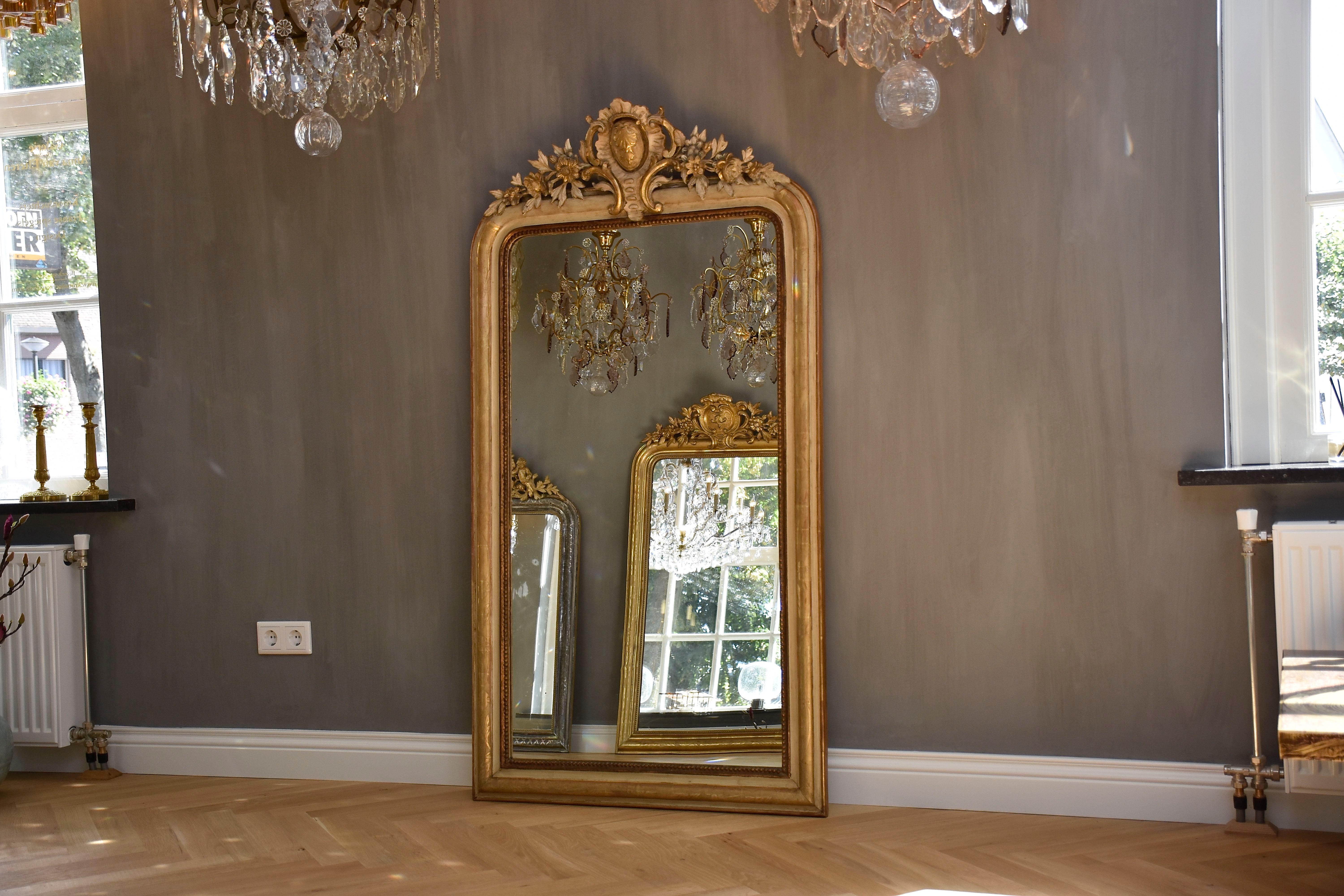 Un joli miroir français du 19ème siècle avec son verre antique d'origine et une belle couronne !
Le cimier représente un schell avec des motifs feuillus et floraux et des rinceaux.
Le cadre a une couleur crème originale et une dorure à la feuille