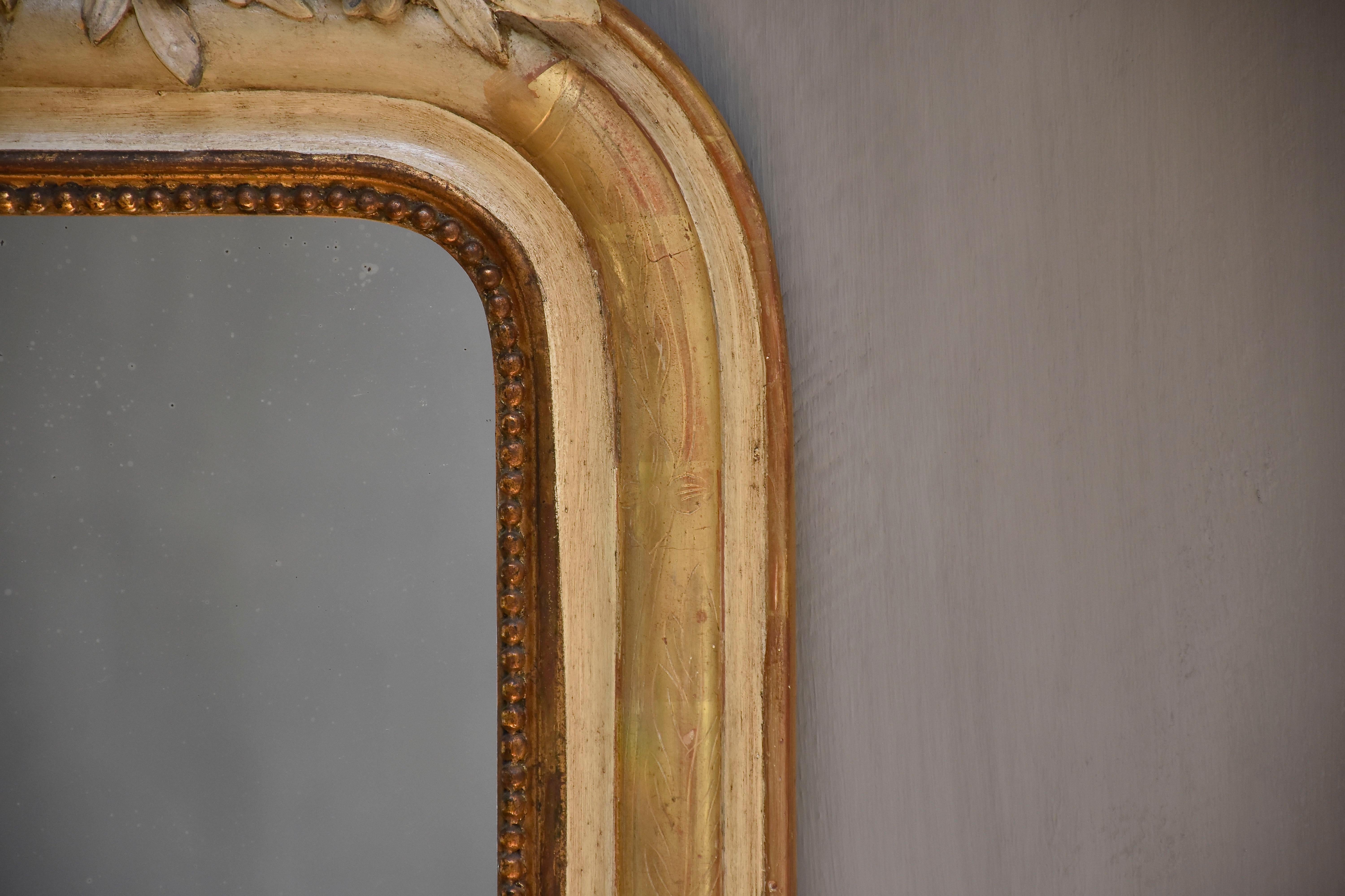 Gilt 19th century antique French mirror with a crest For Sale