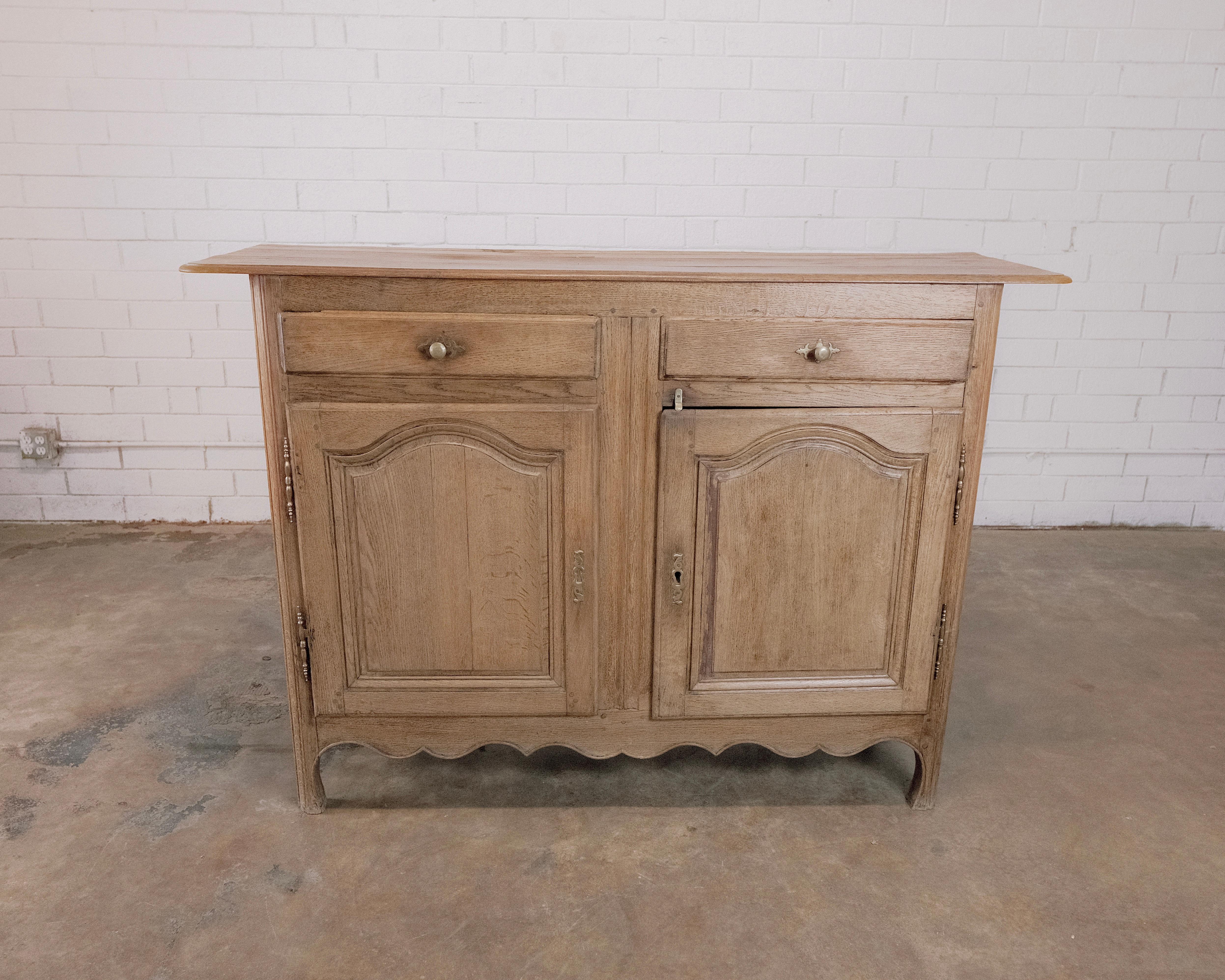 19th Century Antique French Oak Cabinet with drawers and beautiful brass hardware. Crafted with meticulous artistry from sturdy oak, this piece stands as a testament to the rustic elegance of a bygone era.

The rich, weathered oak exudes a warmth