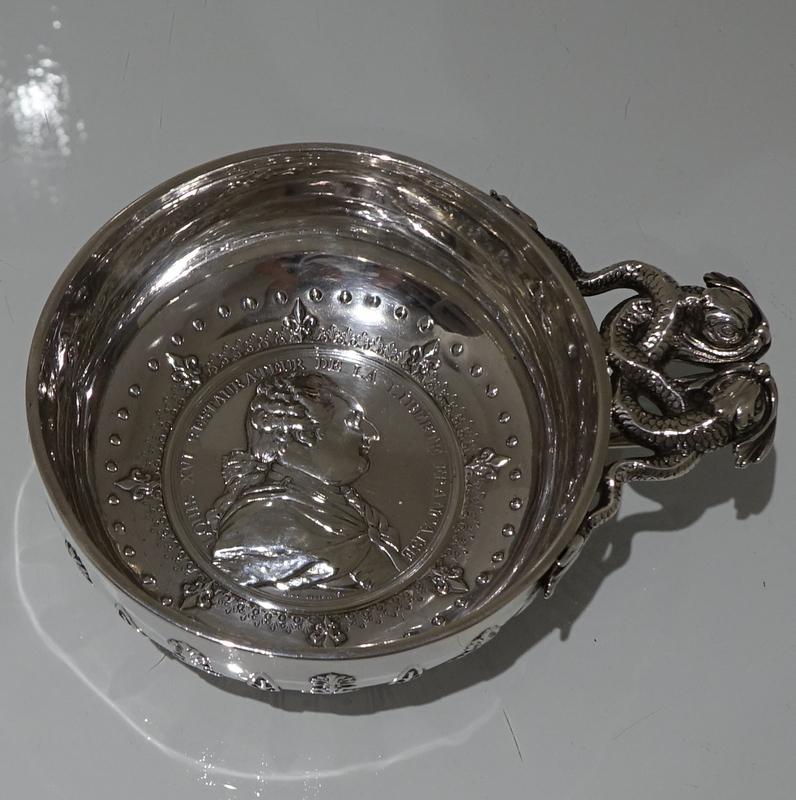 A very large and extremely good quality European silver wine taster decorated with ornate workmanship to the outer bowl and an inner coin for highlights. The handsome cast handle is elegantly formed as two entwined sea serpents.

 

Measures: