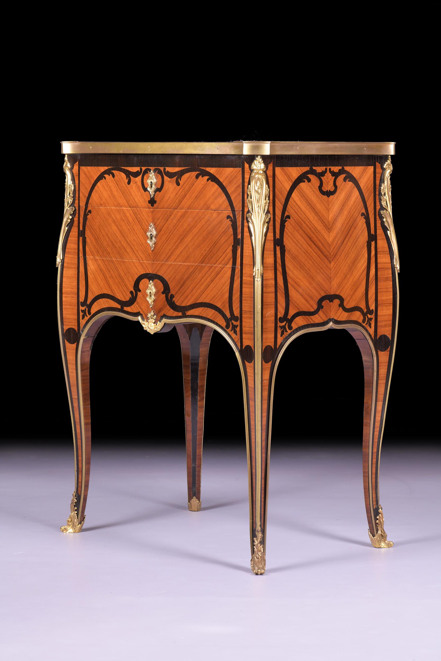 A very fine French Tulipwood marquetry and ormolu mounted commode of neat proportions, of compact rectangular shape, with out set corners inlaid with floral sprays, fitted with three graduated drawers, on slender cabriole legs. 

Circa