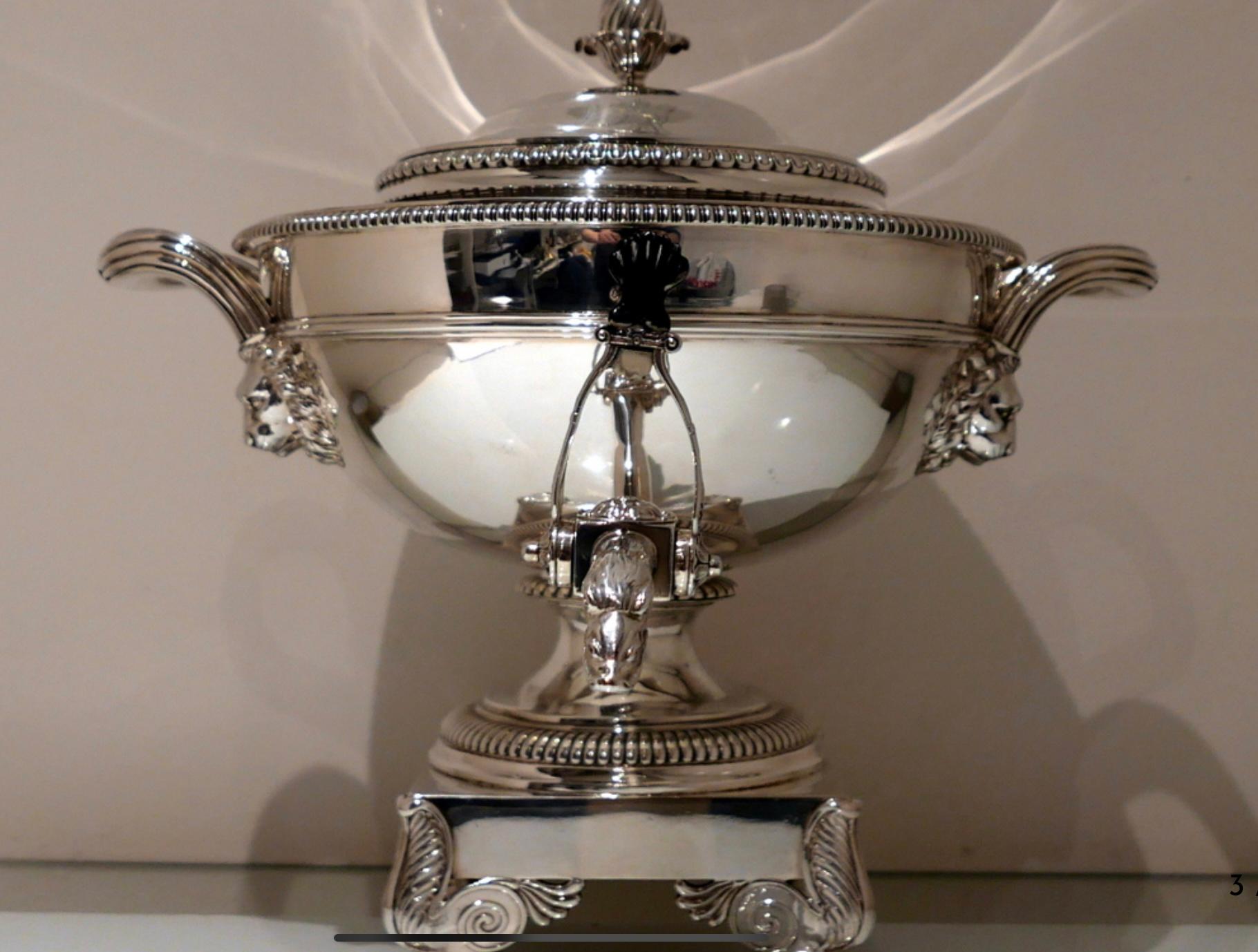 A truly stunning silver hemispherical tea urn decorated with gadroon borders for highlights.  The body has a stylish  upper girdled wire and a ‘serpent’ themed tap.  The lion mane handles and elegant ornate spreading pedestal foot complete a