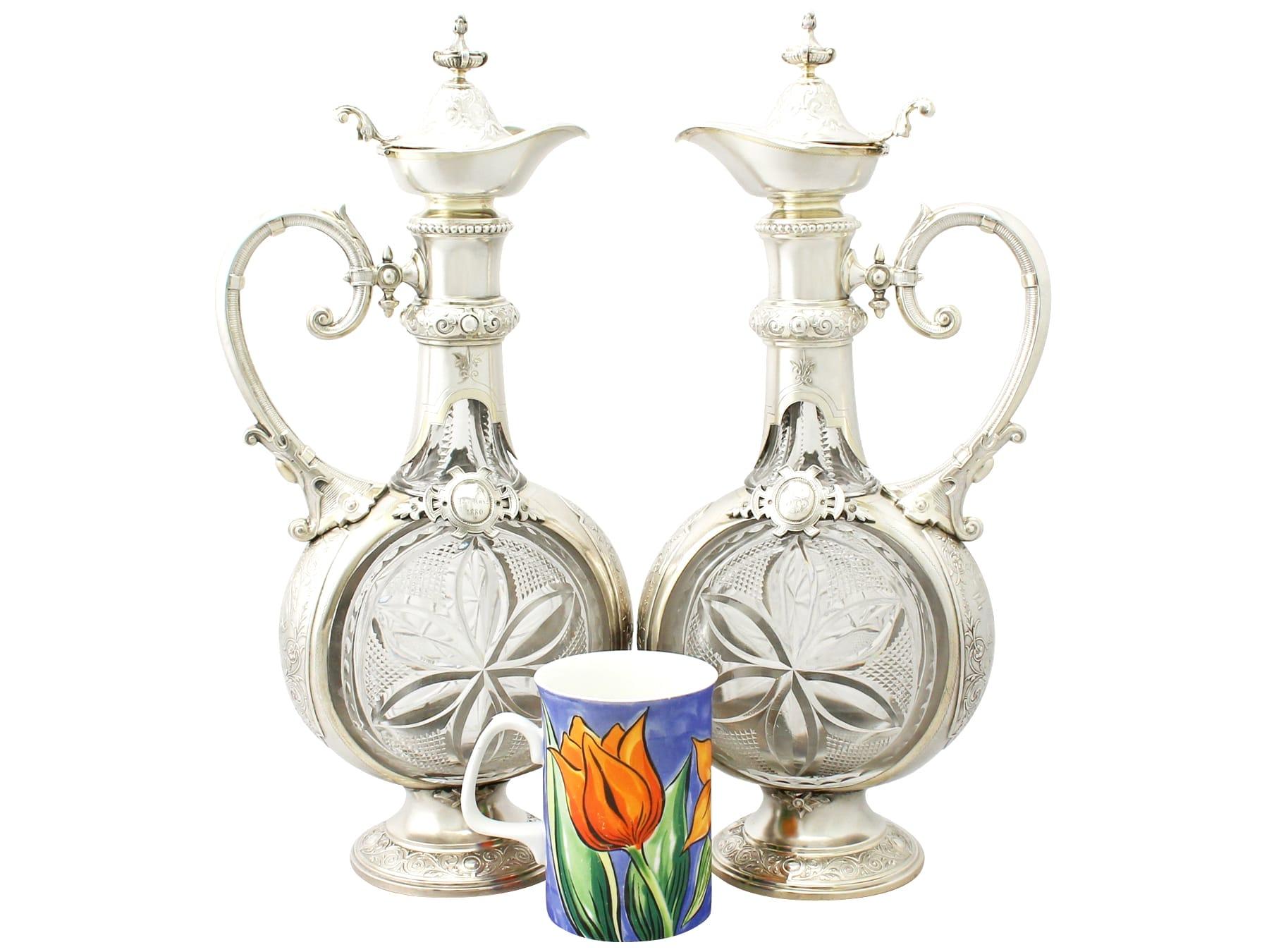 A magnificent, fine and impressive pair of antique German silver and cut glass claret jugs; an addition to our wine and drinks related silverware collection.

These magnificent antique German silver and glass claret jugs have a moon flask shaped