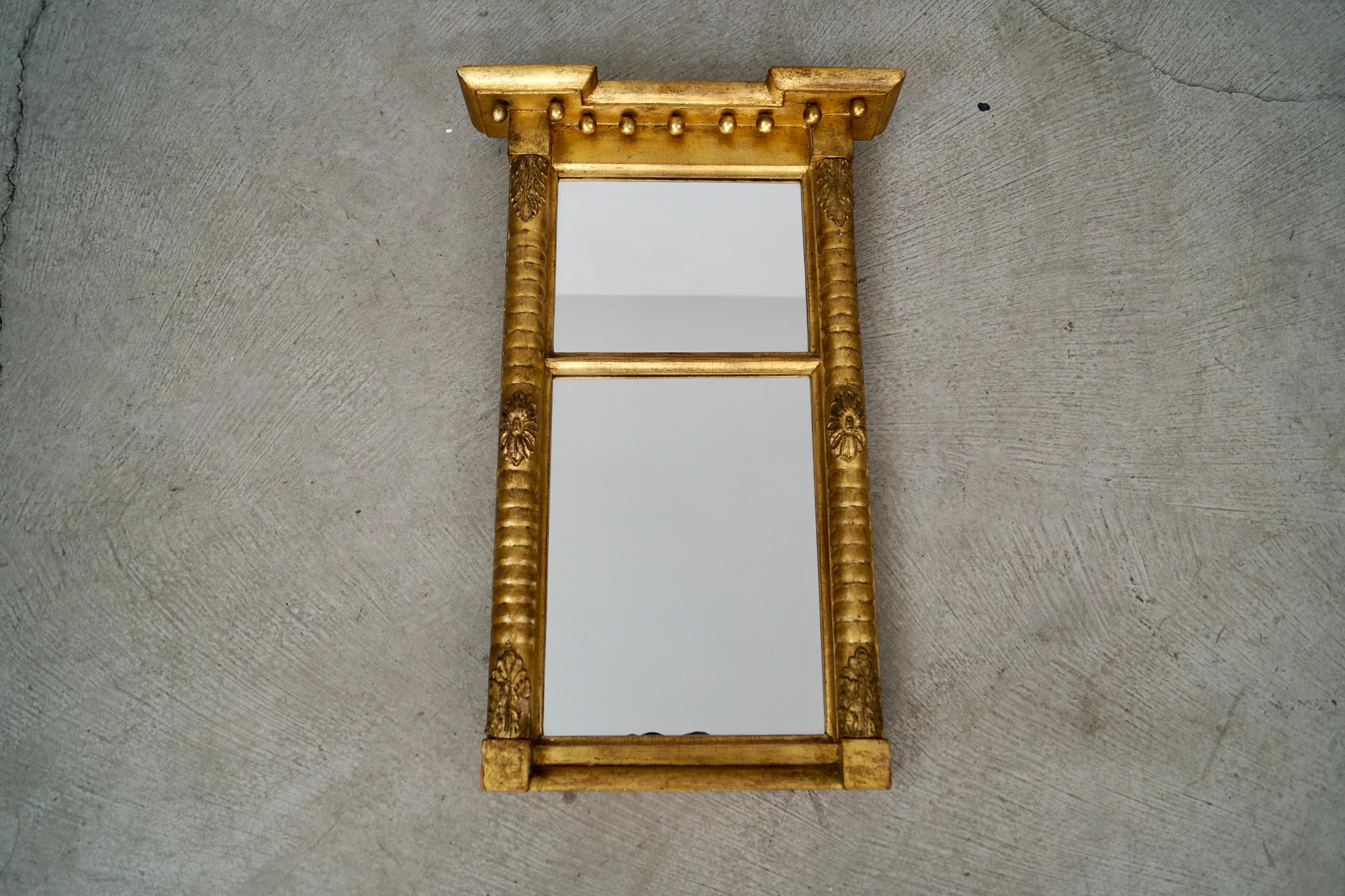 Se vende antiguo espejo de pared dorado del siglo XIX. Es de madera maciza, y tiene bonitos detalles y madera tallada por todas partes, y bolas en la parte superior. La madera está dorada y muestra una maravillosa pátina vintage en el pan de oro.
