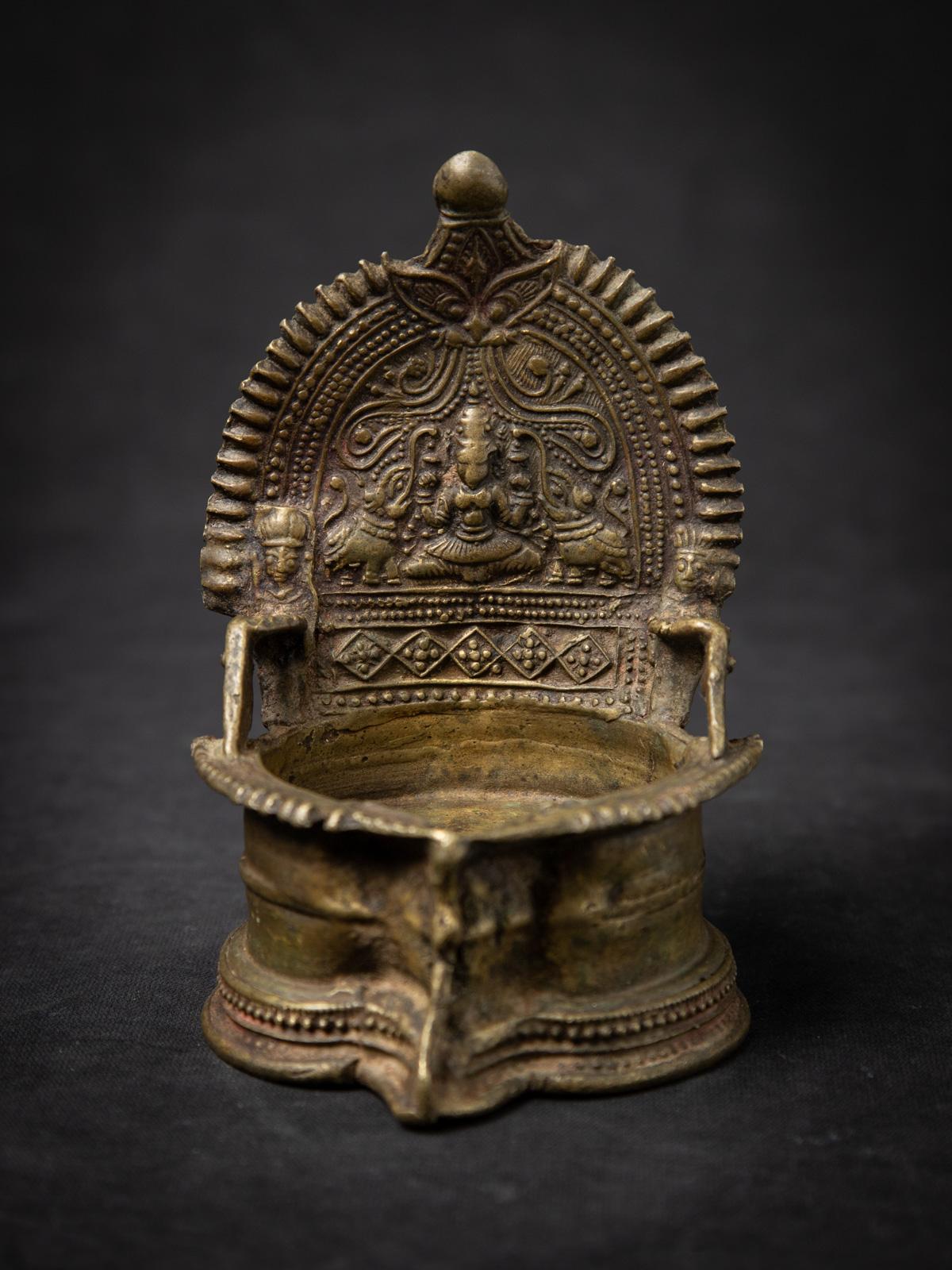 Diese antike indische Öllampe aus dem 19. Jahrhundert ist ein wunderschön gearbeiteter Devotionaliengegenstand und ein schönes Beispiel für traditionelle indische Metallarbeiten. Die aus Messing gefertigte Lampe ist 14,2 cm hoch, 9,3 cm breit und