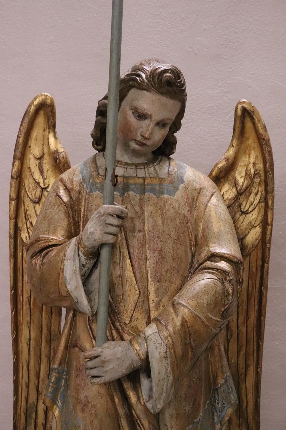 Rare antique angel sculpture. The angel is completely lacquered and gilded with large wings, holding a large candle. They are fantastic large in size made of hand carved wood and gilded with gold leaf. The gold has acquired a beautiful old patina.