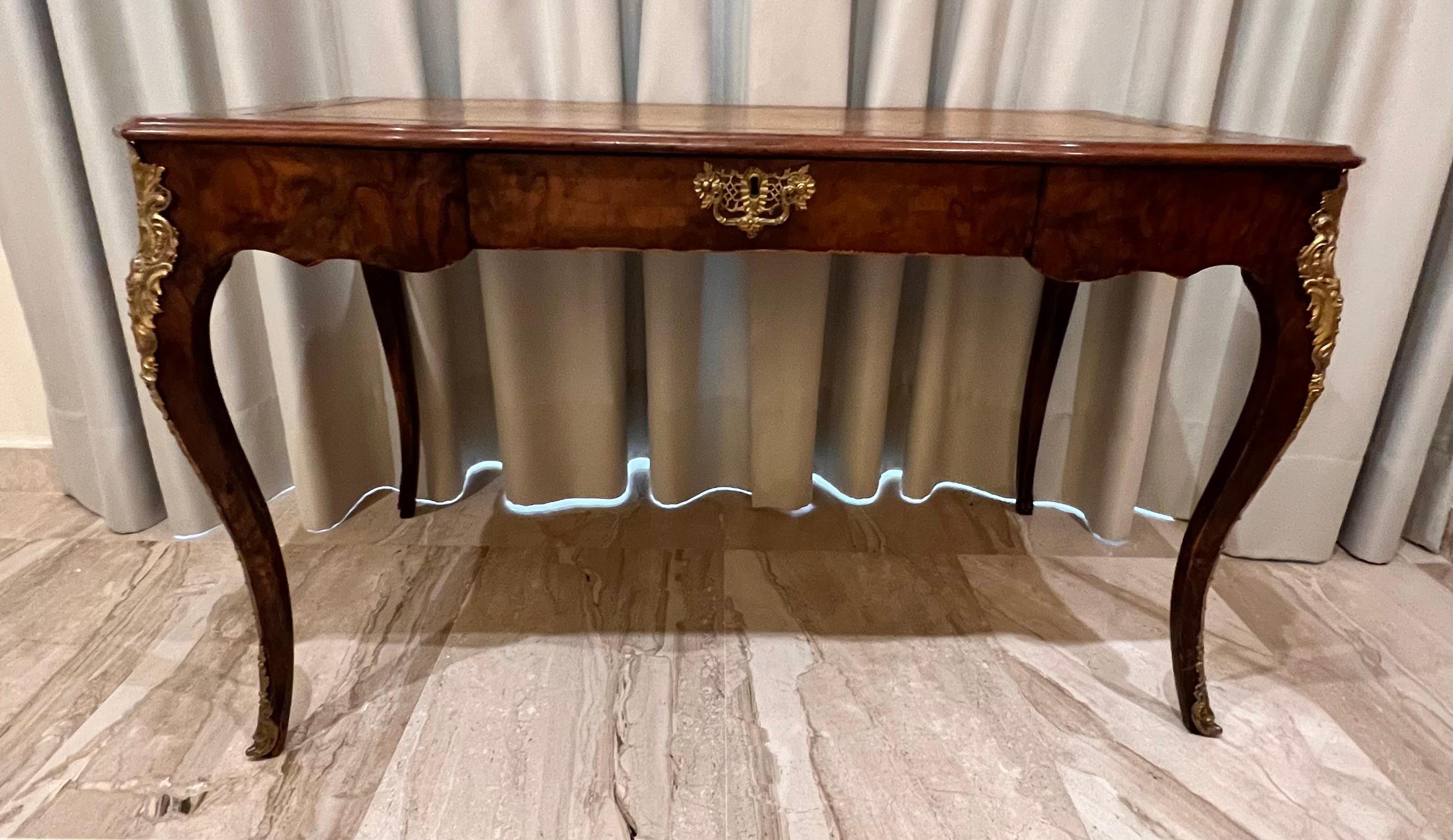 Castle worthy desk, solid wood. Rosewood veneer edged by finely engraved brass fittings. On angled, with four looking forward, imposing curly legs, on all sides scalloped. Profiled and curved writing tablet with real leather, gold embossing. Highly